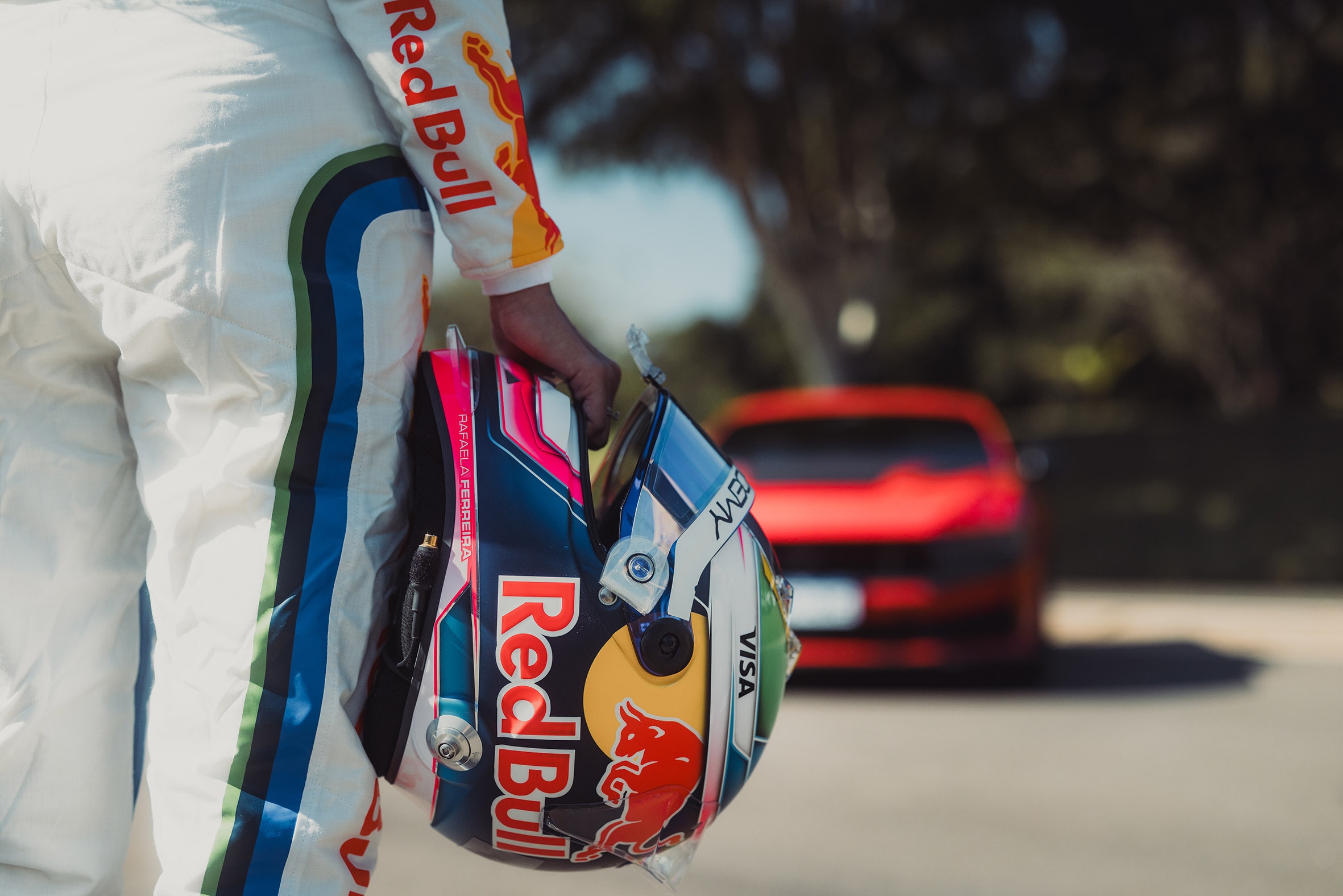 Capacete da piloto Rafaela Ferreira com um Ford Mustang ao fundo