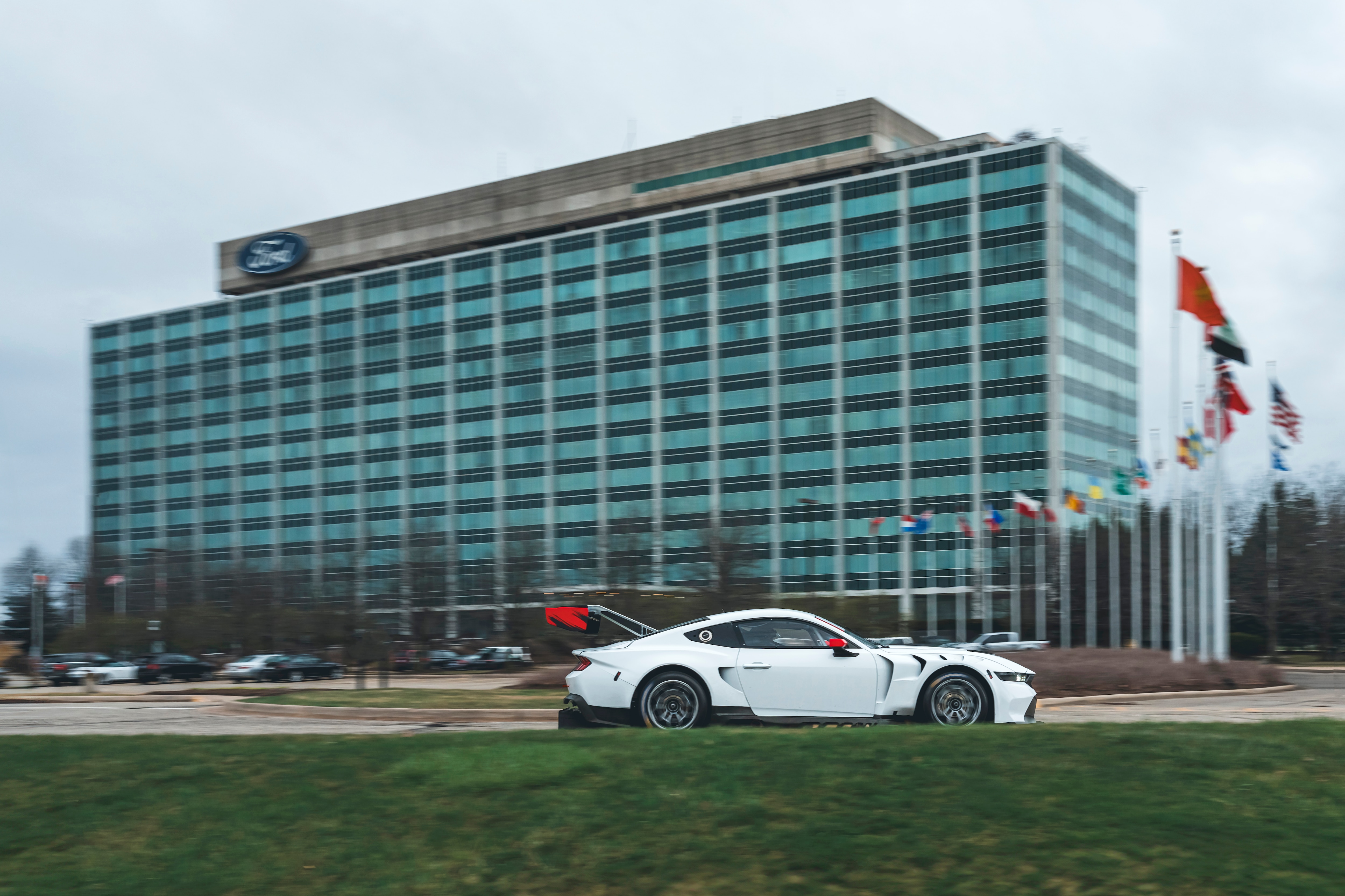 Driver side of Mustang GT3 in all white wrap in front of Ford World Headquarters.