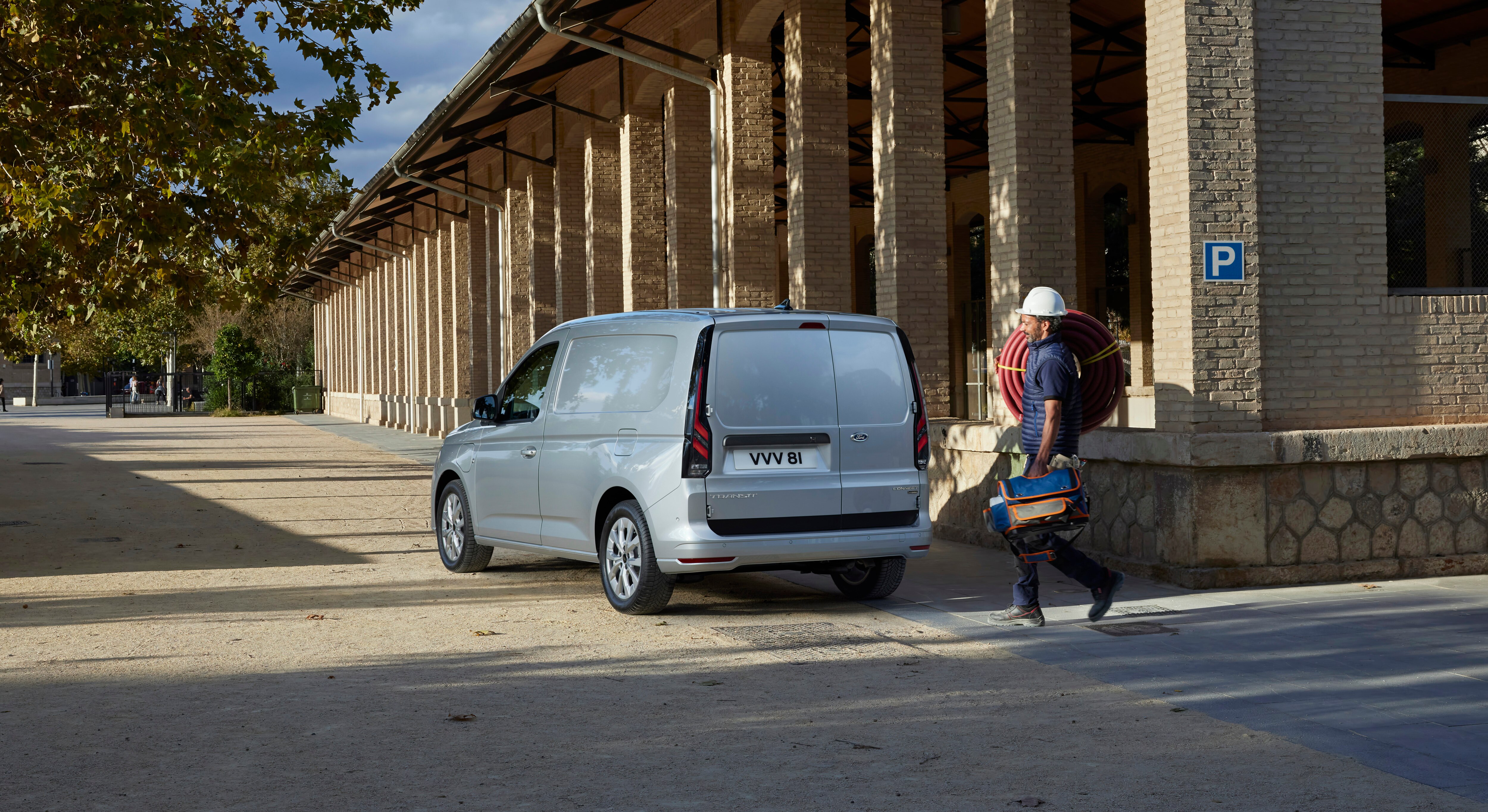 a woman walking with tools towards a van
