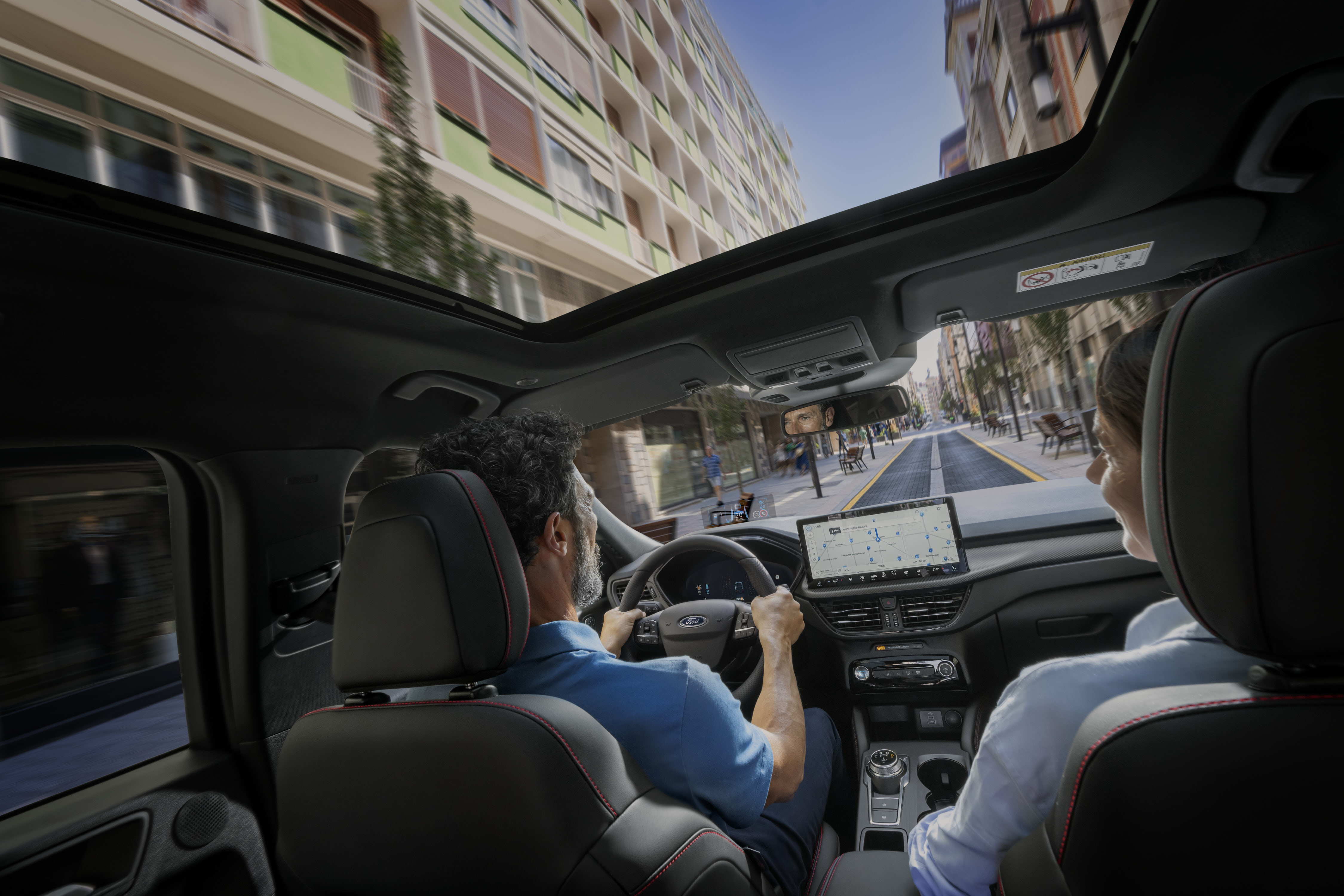 a shot of a couple driving down a street inside the car 