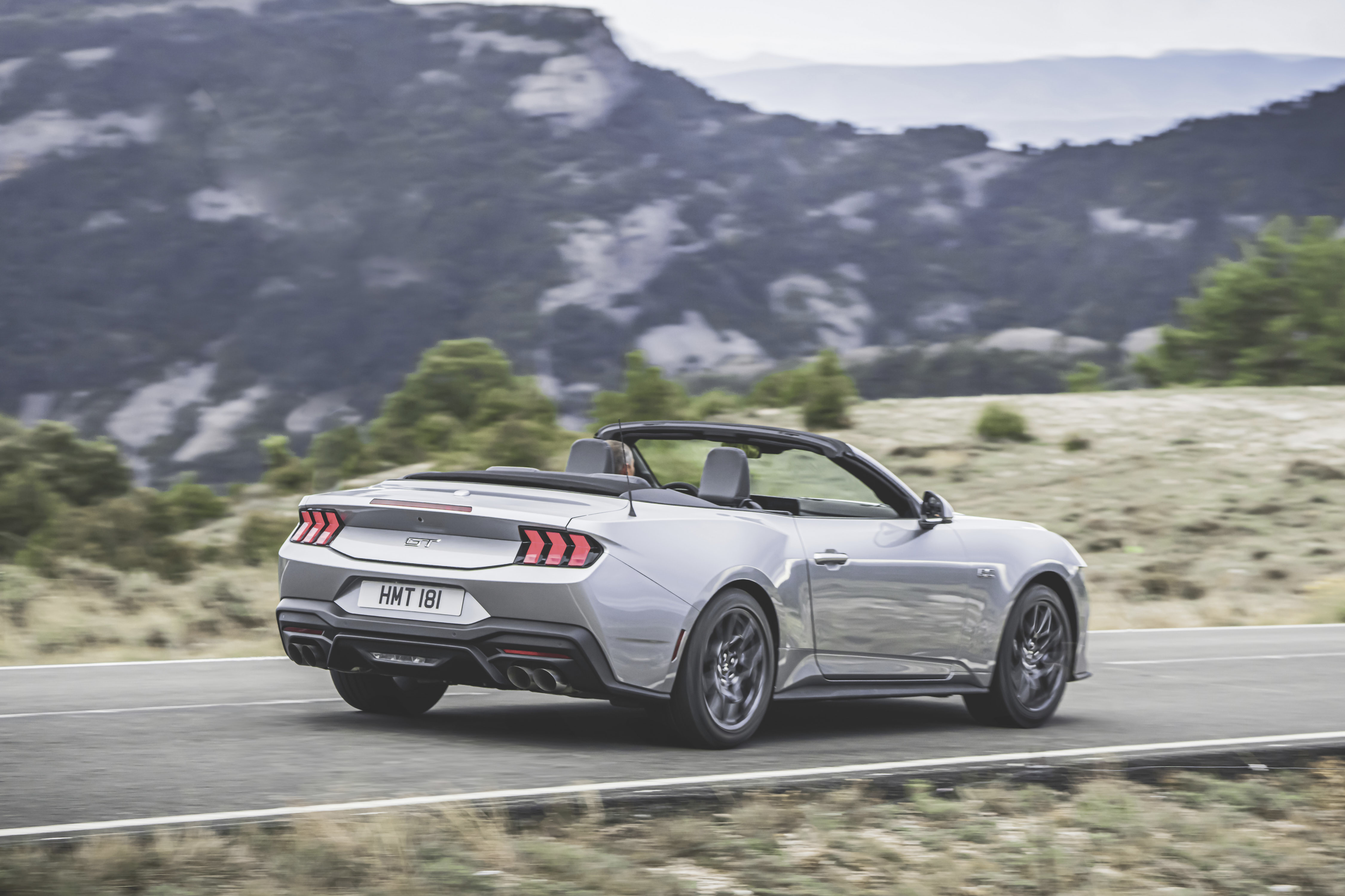 silver mustang driving with top down