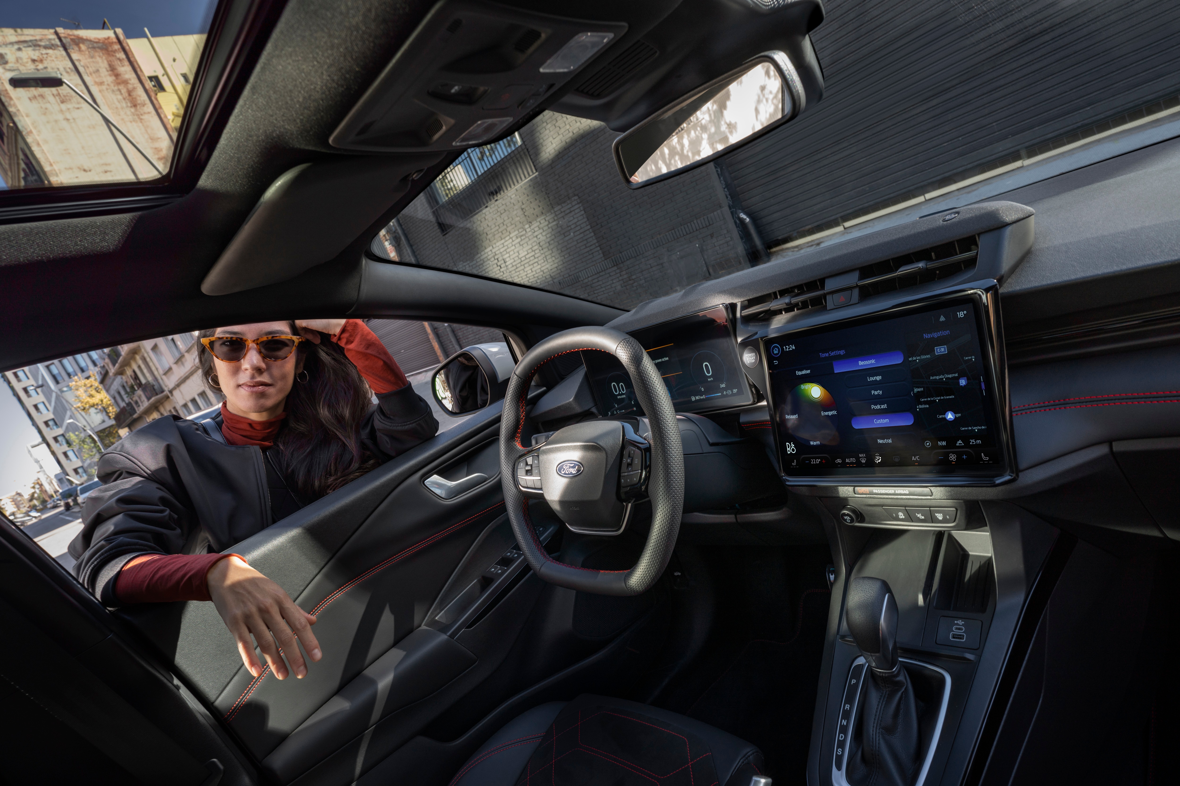 a woman in sunglasses leaning through the front window of a car