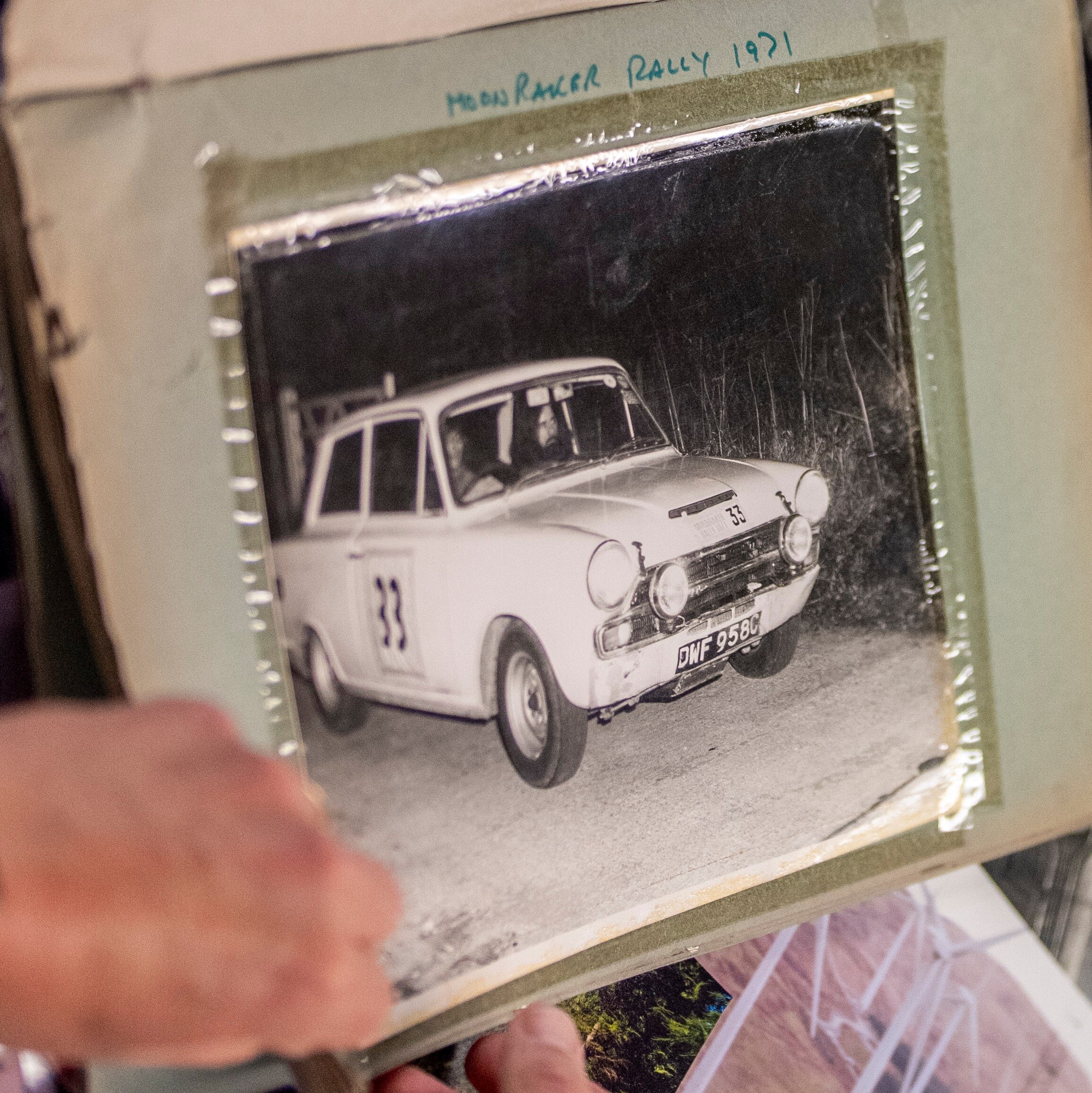 Black and white photo in scrapbook showing Peter in a Cortina GT on his first ever rally