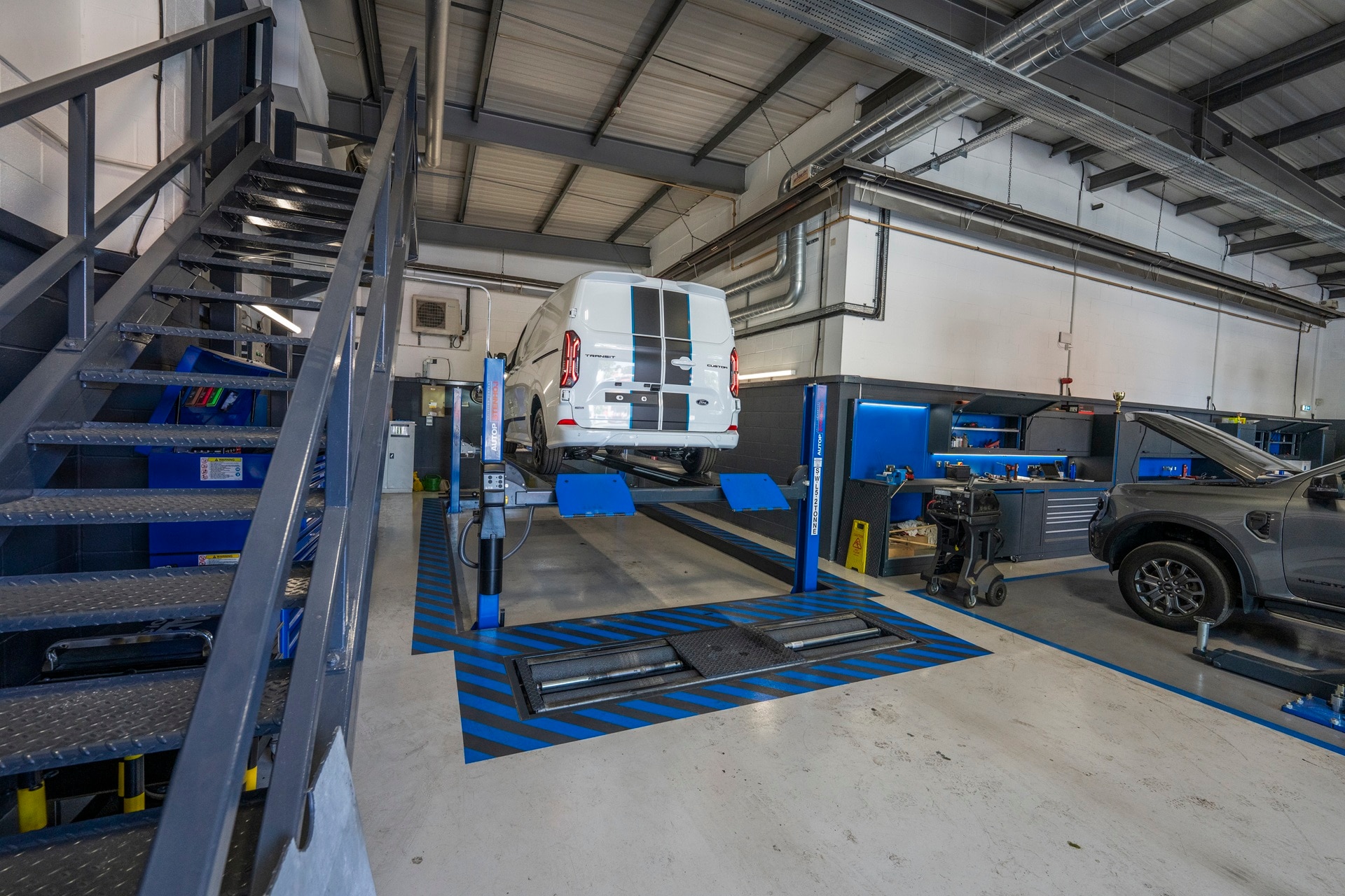 Ford Transit Custom up on ramps in workshop at a Transit Centre