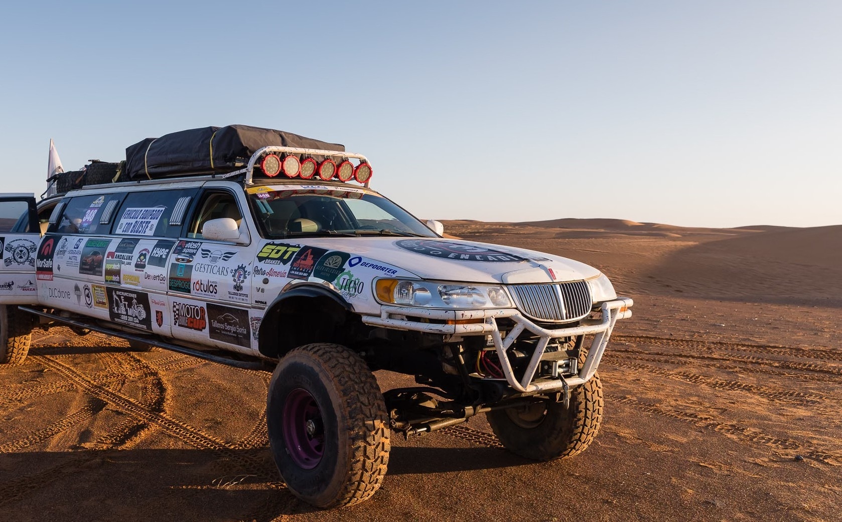 Front of stretched limo parked in desert at sunset