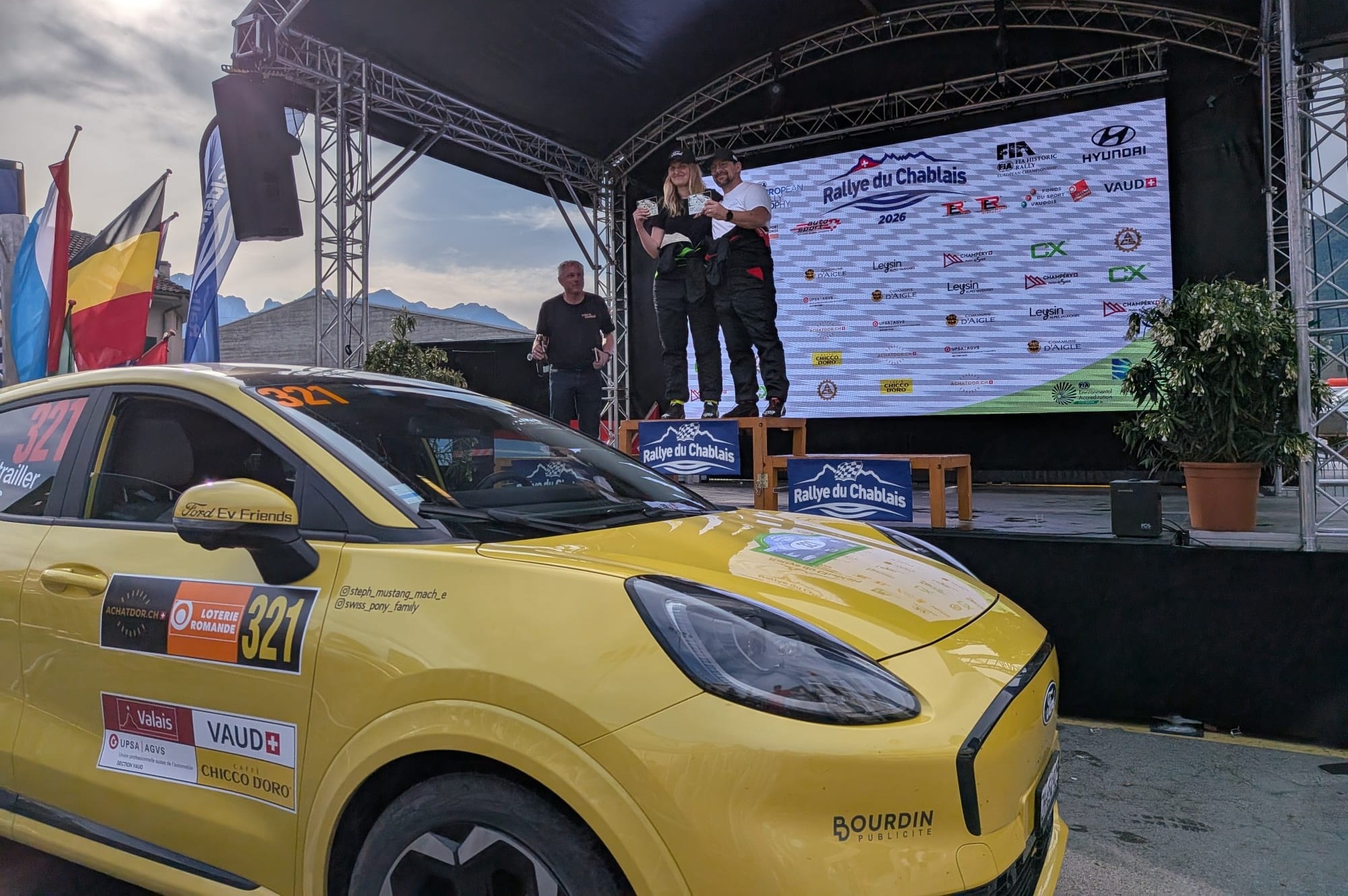 Stéphanie and and Guillaume take to the podium after their win, with the Ford Puma Gen-E standing proud with them.