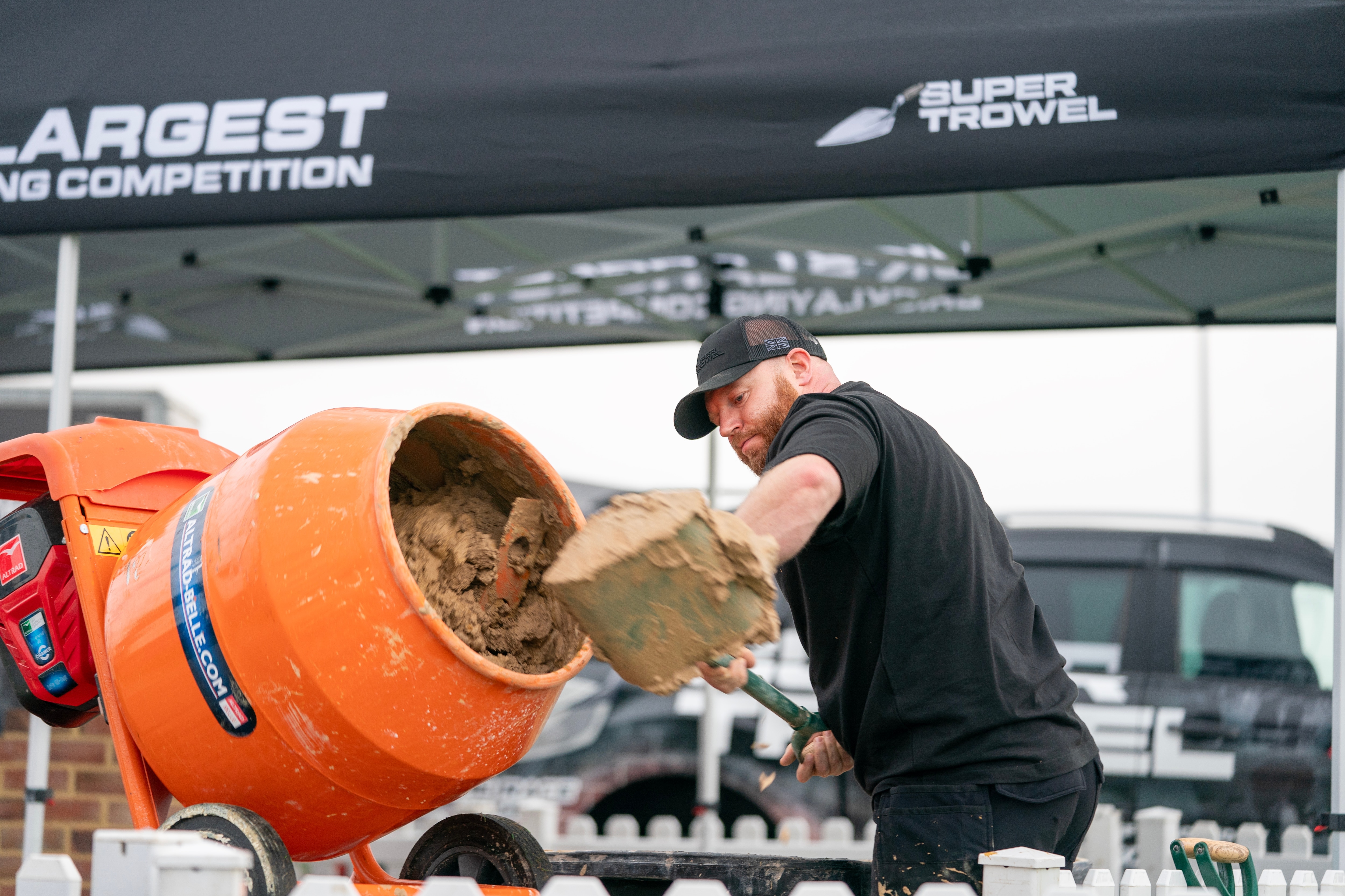 Man shovels cement into a mixer at Super Trowel event