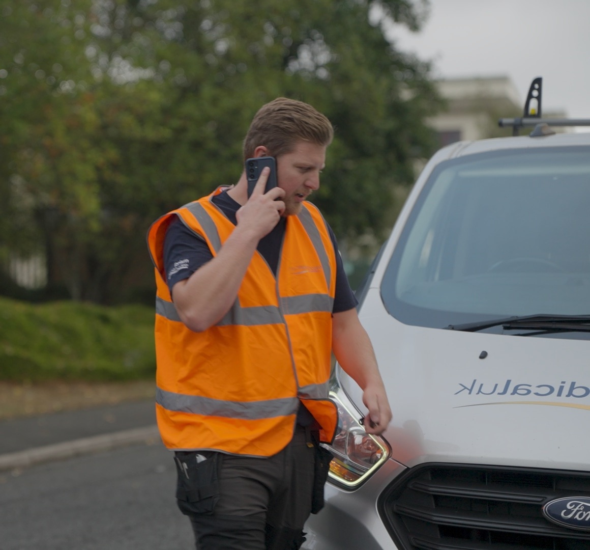 Prism driver on the phone to Ford Uptime Services agent while parked by the side of the road