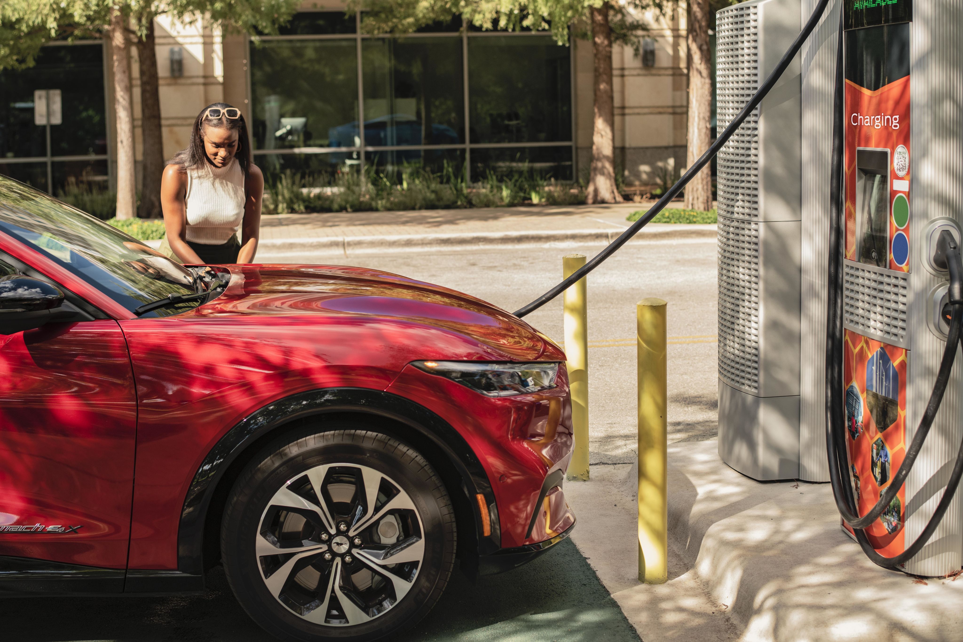 Customer charges a Ford Mustang Mach-E at a BlueOval Charge Network electric vehicle charger