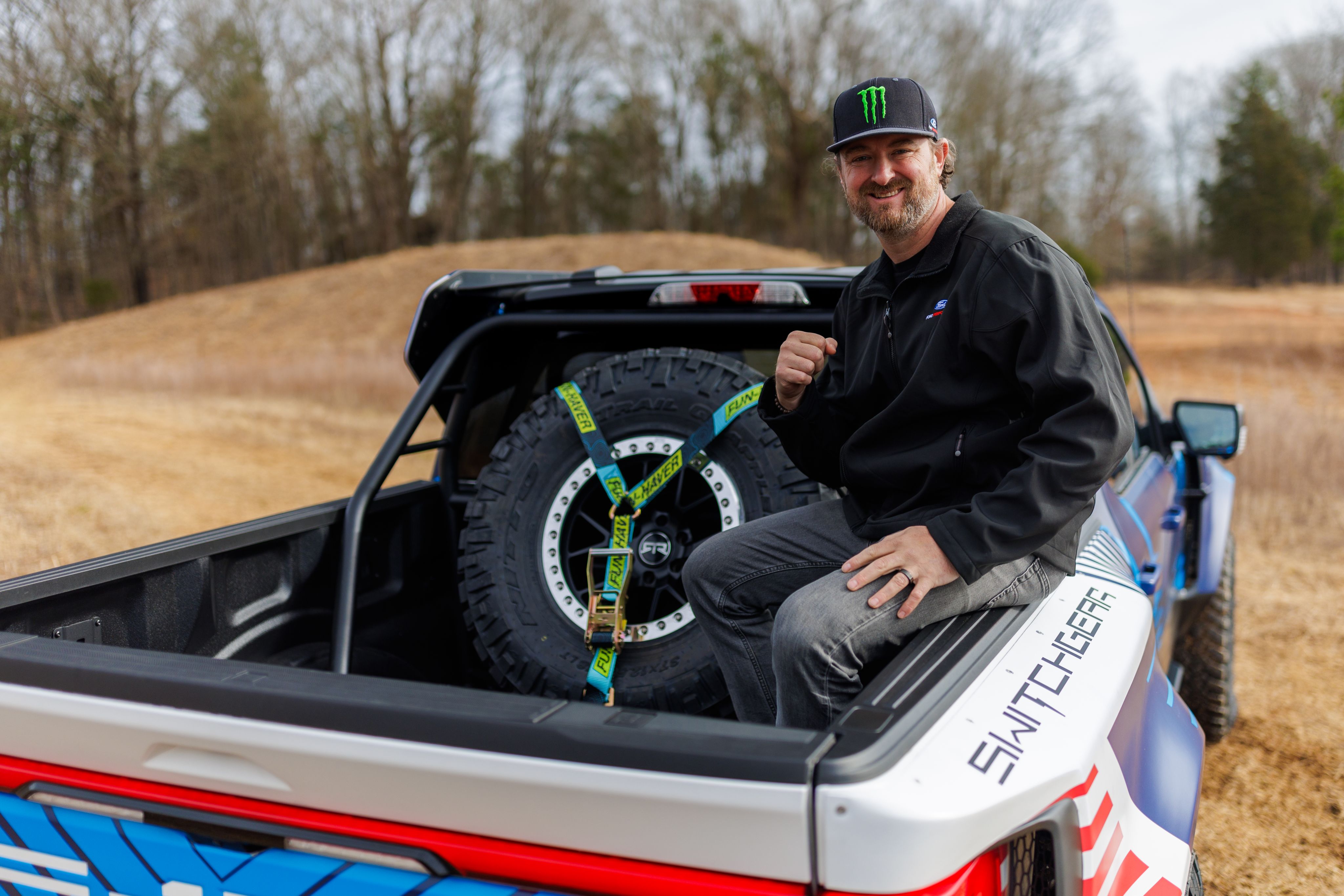 Vaughn Gittin Jr. poses in bed of F-150 Lightning Switchgear.