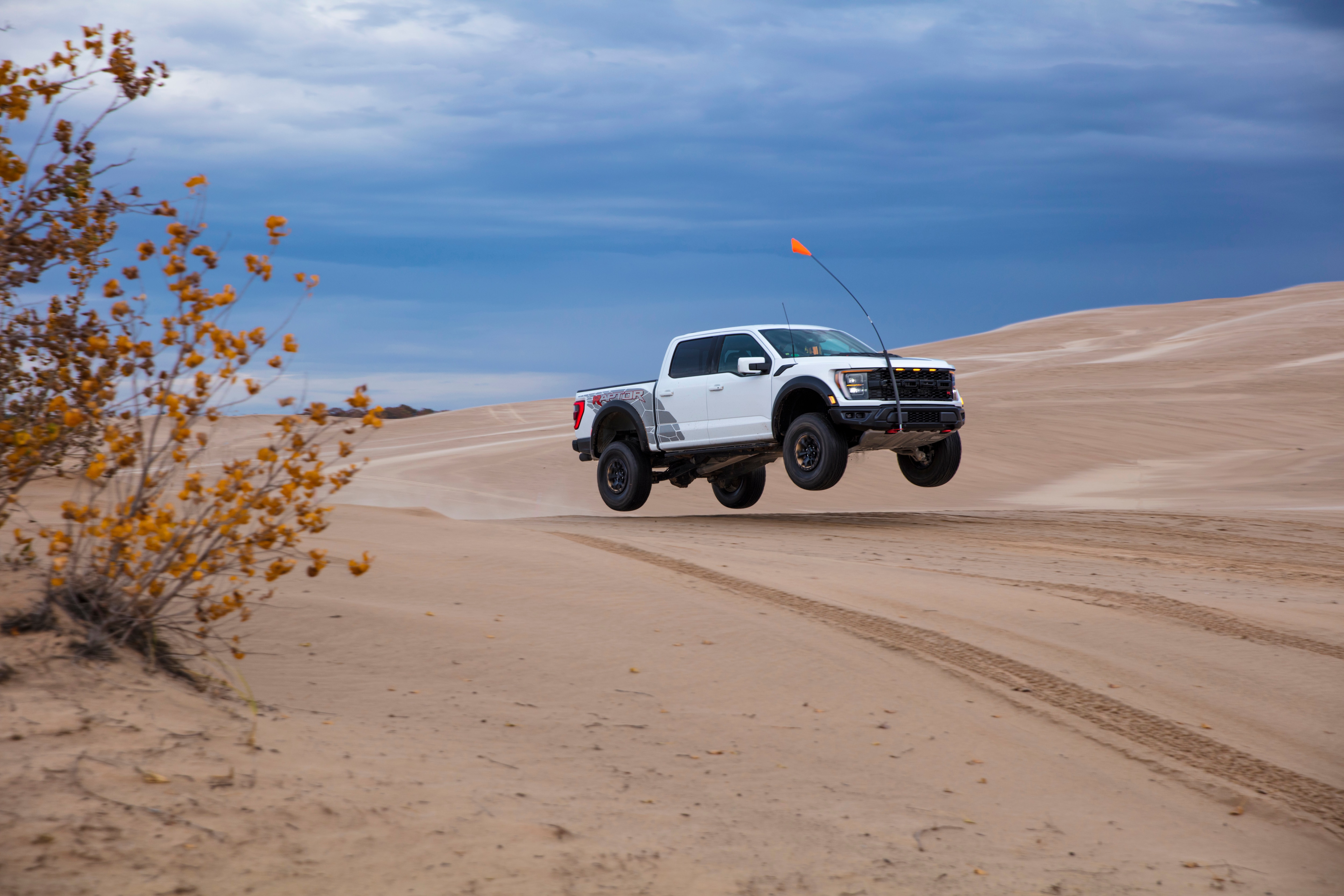 Preproduction 2023 F-150 Raptor R with aftermarket flag and optional equipment. Available late 2022. Professional driver on a closed course. Always consult the Raptor supplement to the Owner’s Manual before off-road driving, know your terrain and trail difficulty, and use appropriate safety gear. 