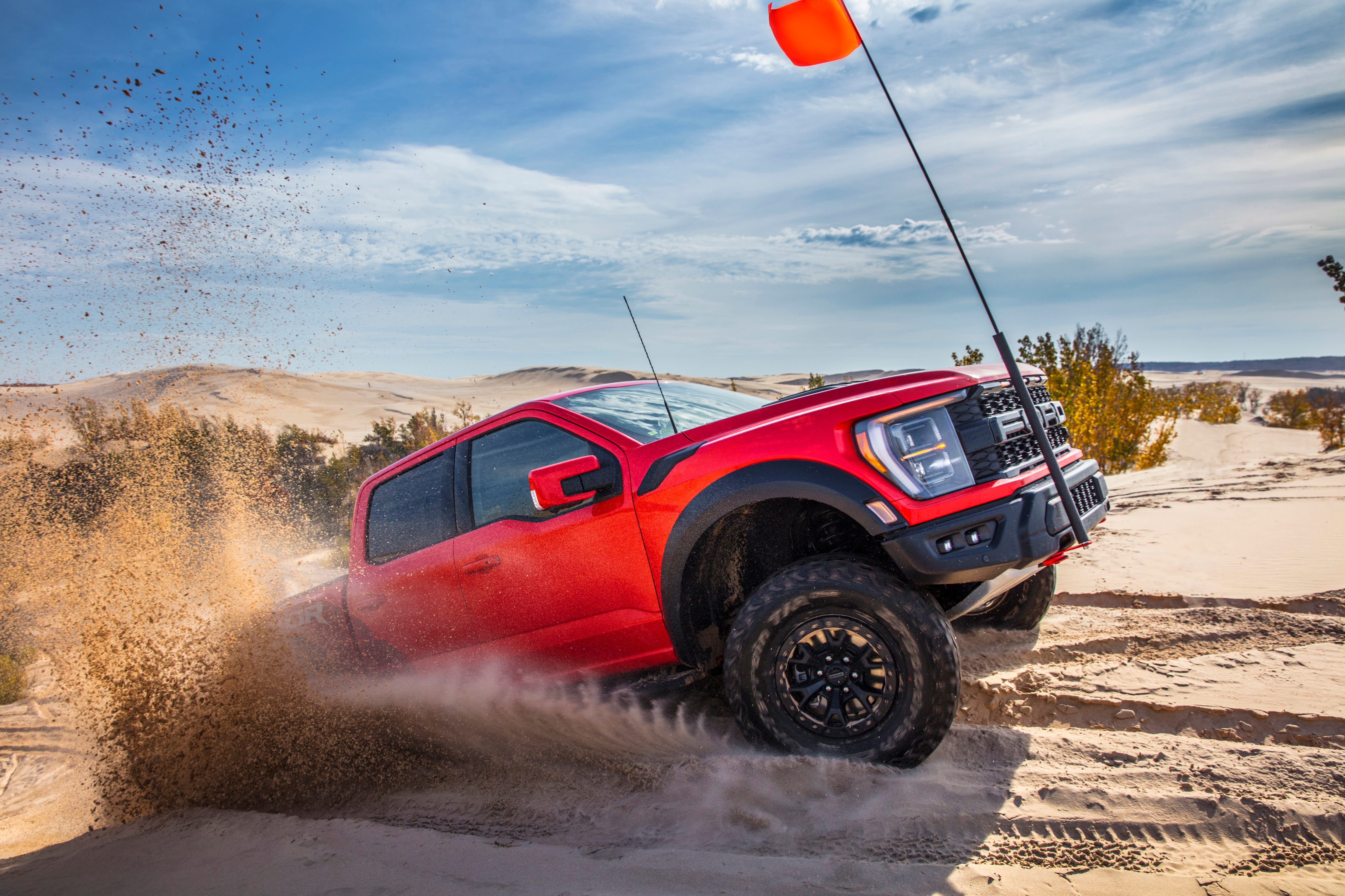 Preproduction 2023 F-150 Raptor R with aftermarket flag and optional equipment. Available late 2022. Professional driver on a closed course. Always consult the Raptor supplement to the Owner’s Manual before off-road driving, know your terrain and trail difficulty, and use appropriate safety gear.