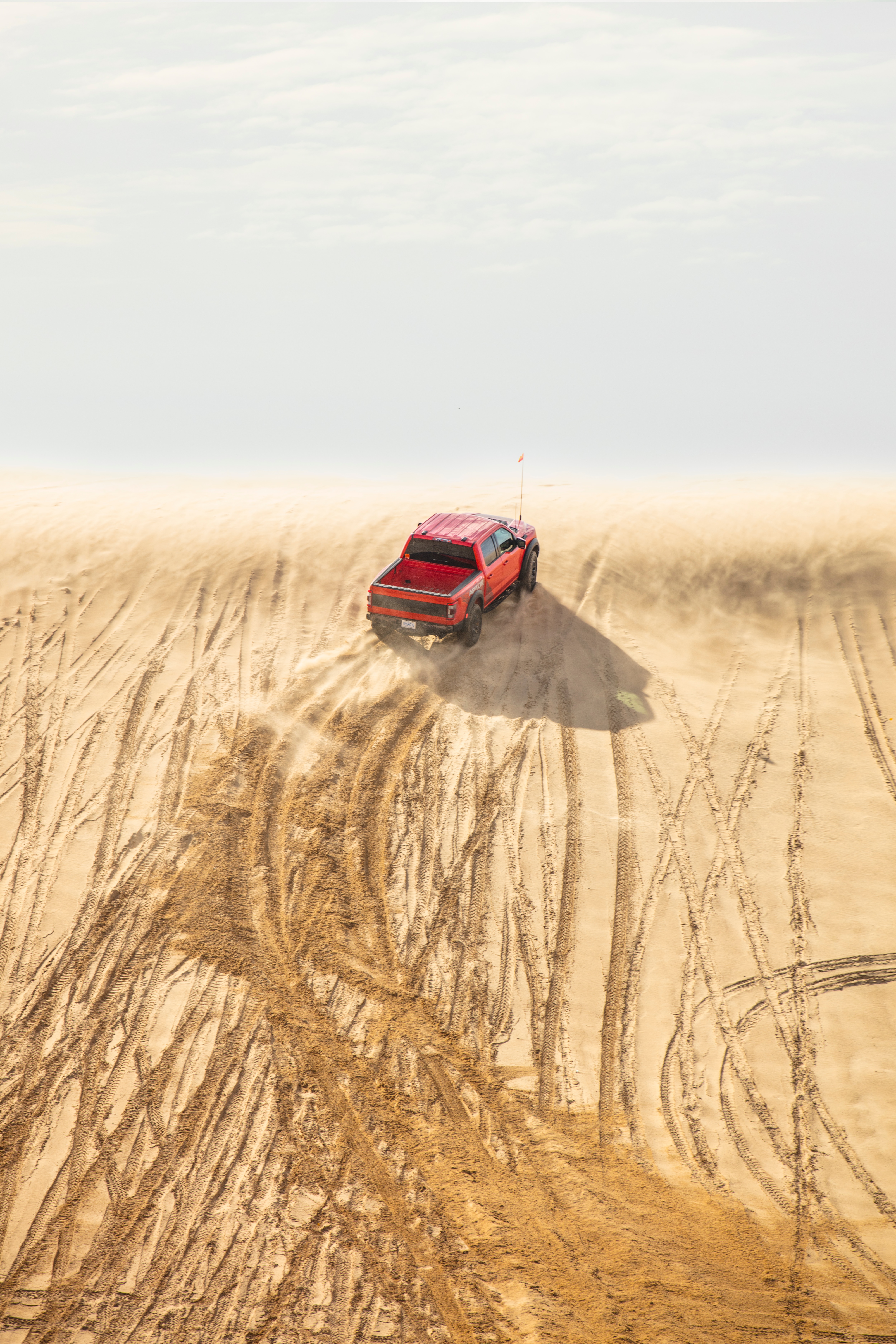 Preproduction 2023 F-150 Raptor R with aftermarket flag and optional equipment. Available late 2022. Professional driver on a closed course. Always consult the Raptor supplement to the Owner’s Manual before off-road driving, know your terrain and trail difficulty, and use appropriate safety gear.