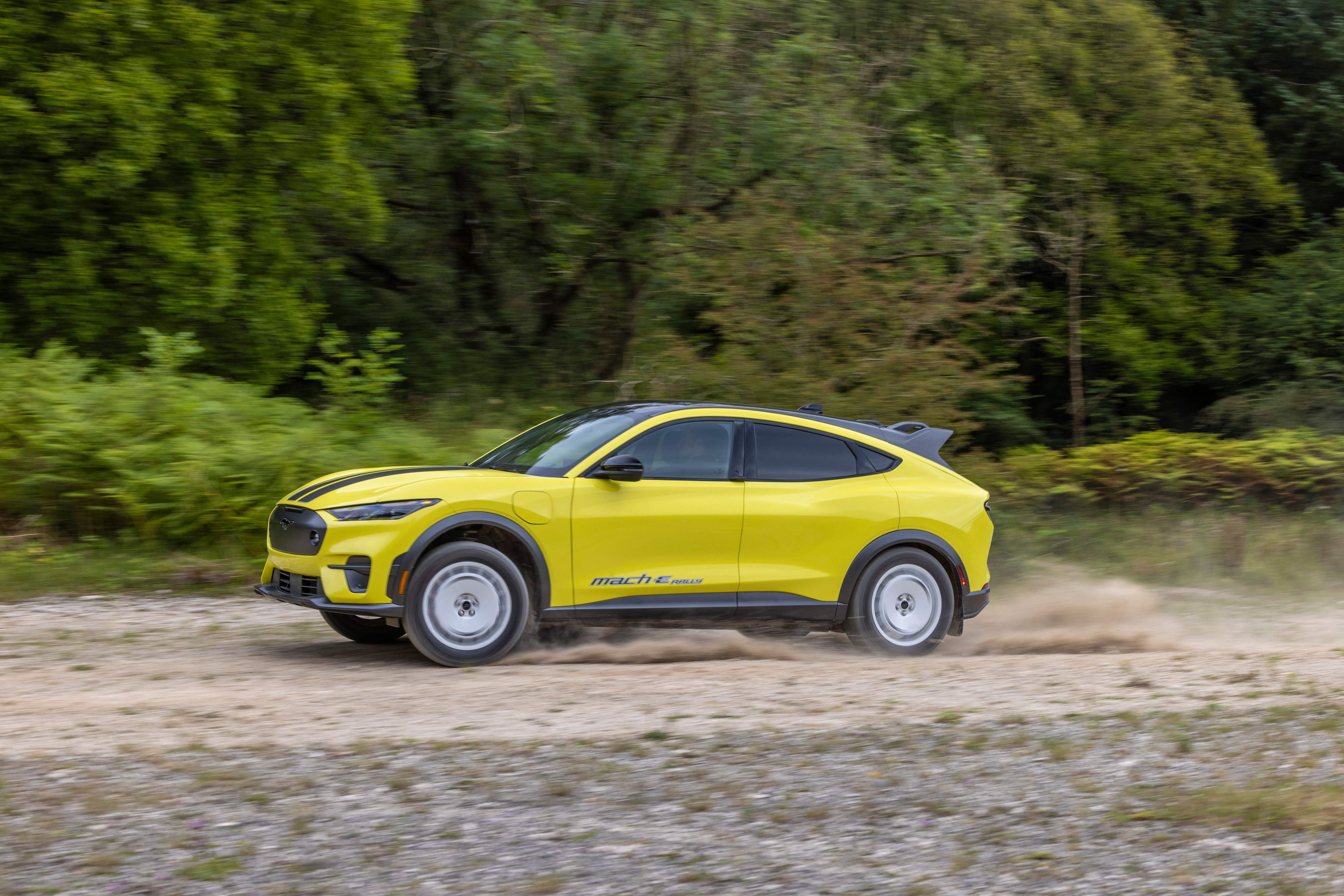 A Mustang Mach-E Rally racing down a dirty road.