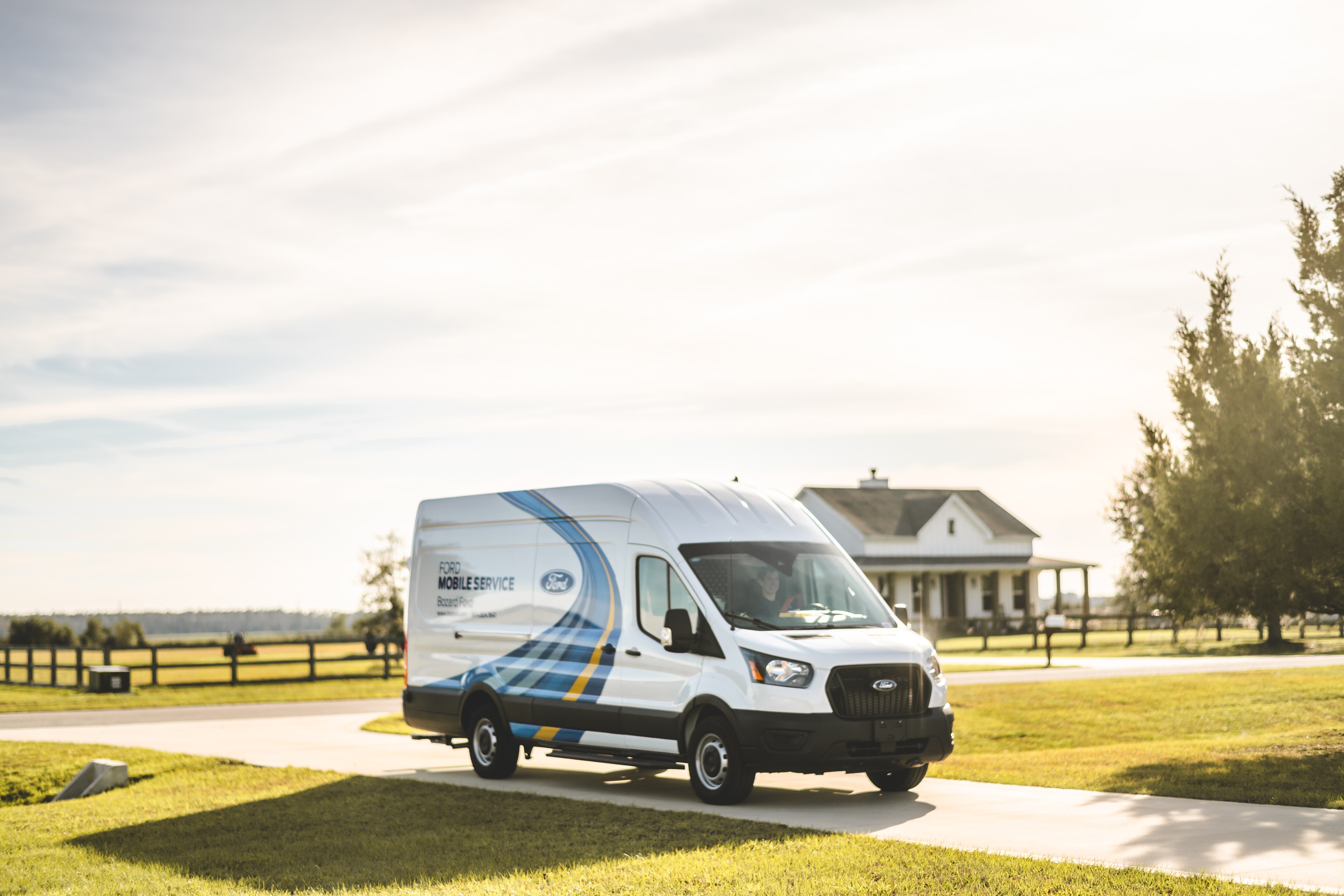 A Ford Transit van parked on the road reads "Ford Mobile Service Bozard Ford" on the side.