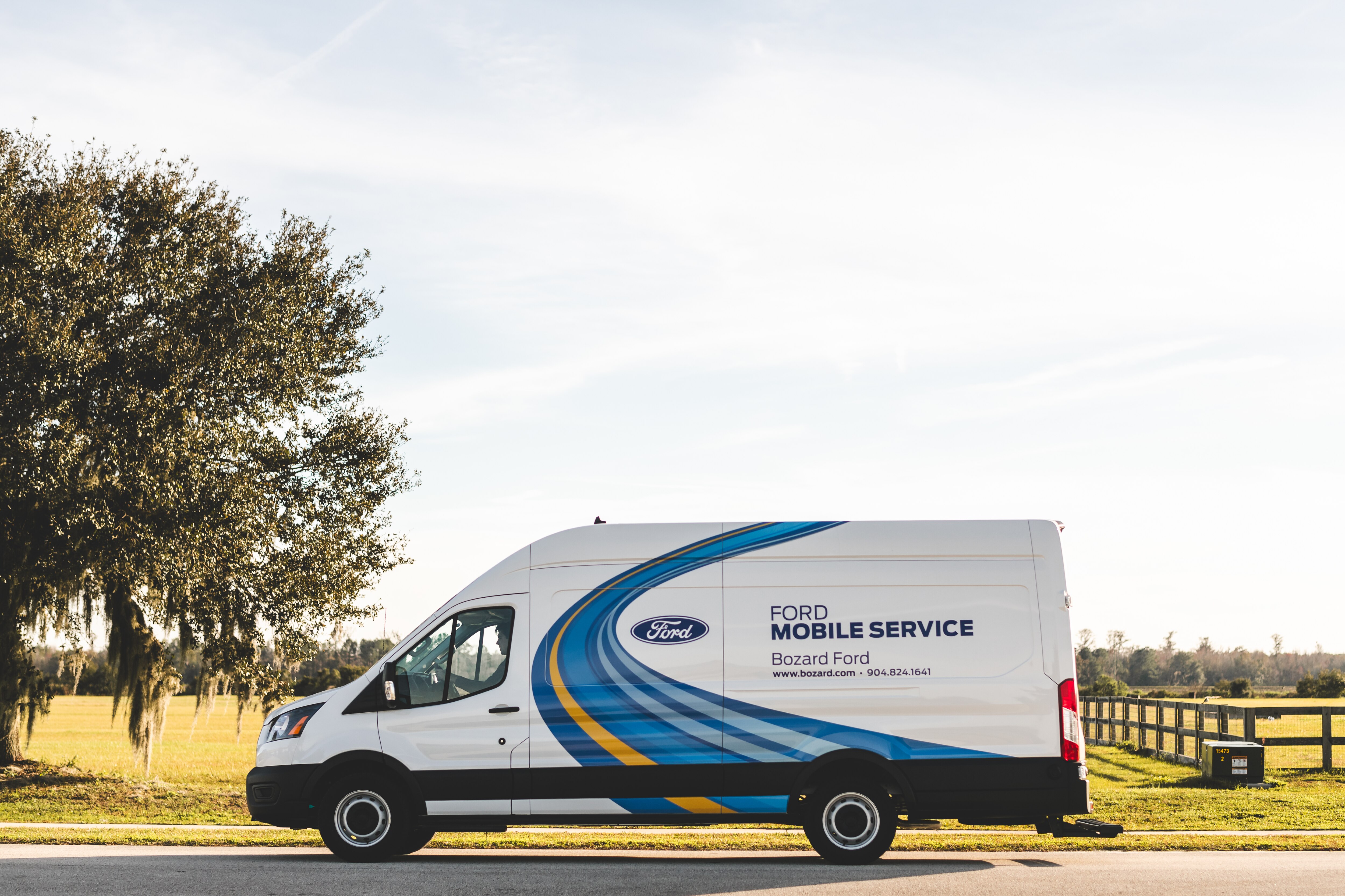 A Ford Transit van parked on the side of the road reads "Ford Mobile Service Bozard Ford" on the side.