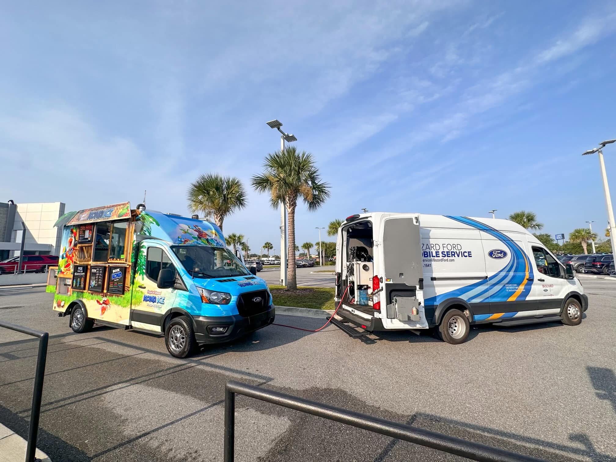 A Ford Mobile Service van is parked in front of a colorful food truck.