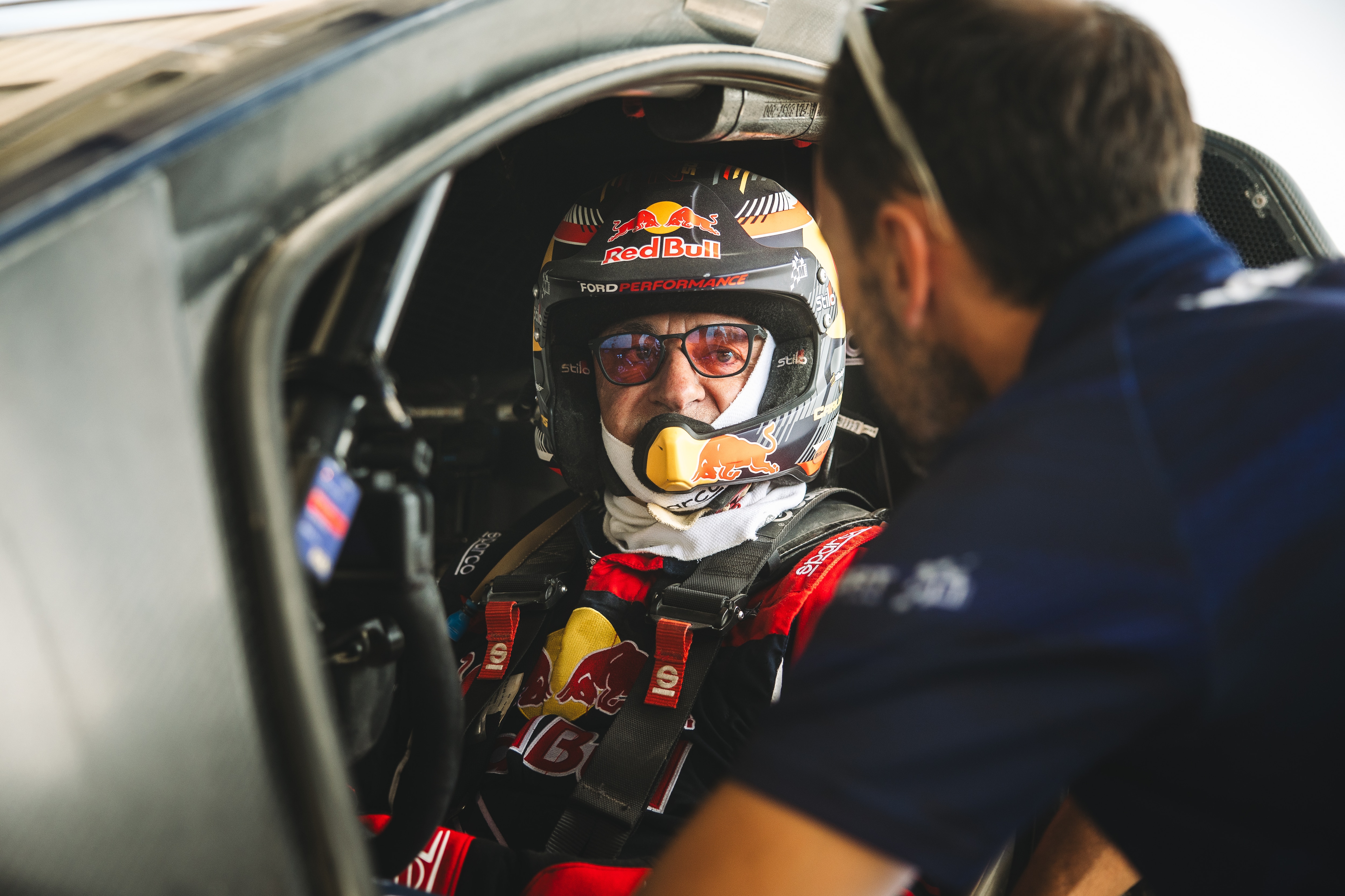 Carlos Sainz Senior with racing gear in the front seat of the racecar ready to go