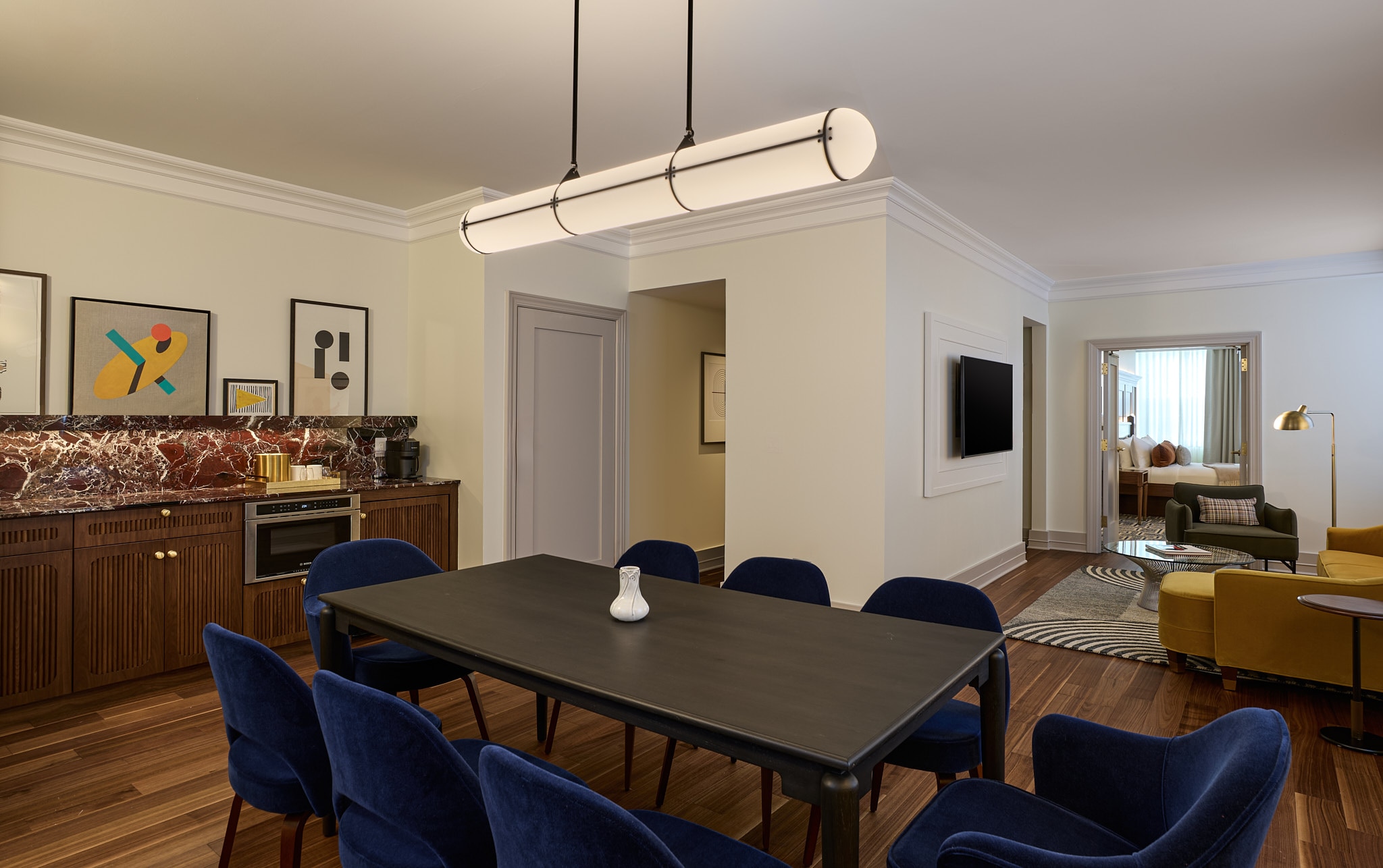 A large dining area with blue chairs and a black table is pictured in the Grand Presidential Suite at the newly renovated Dearborn Inn