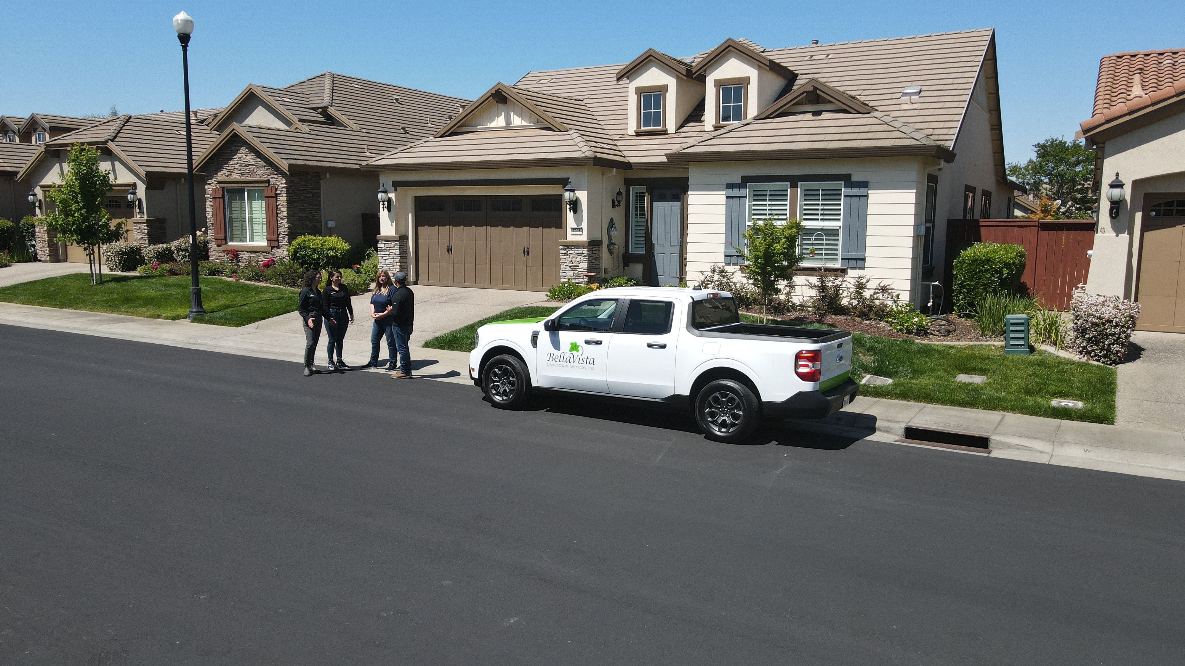 Four individuals gather in front of one of BellaVista’s Ford Maverick® trucks.