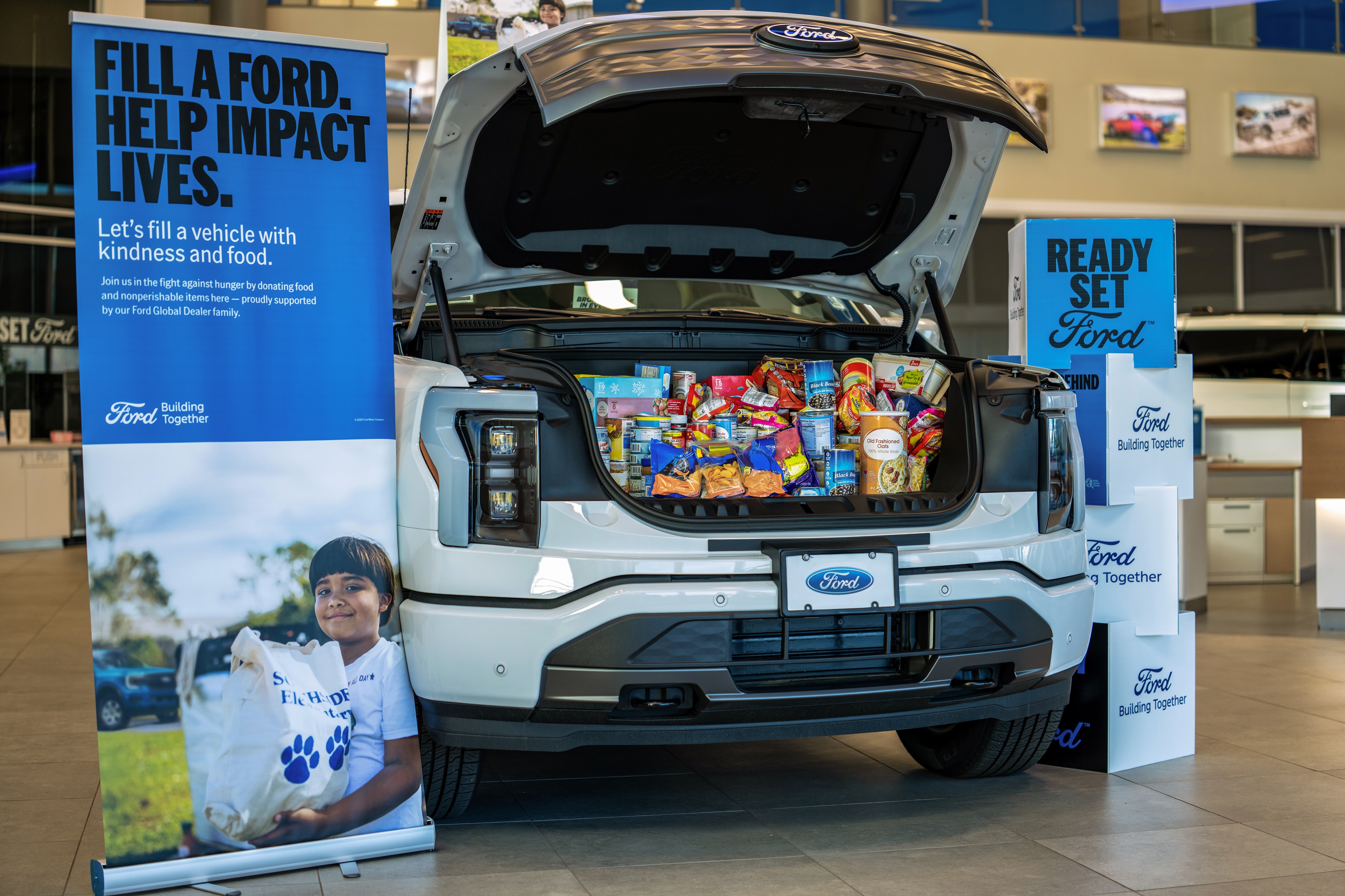 The front trunk of a Ford electric truck filled with food items for donation