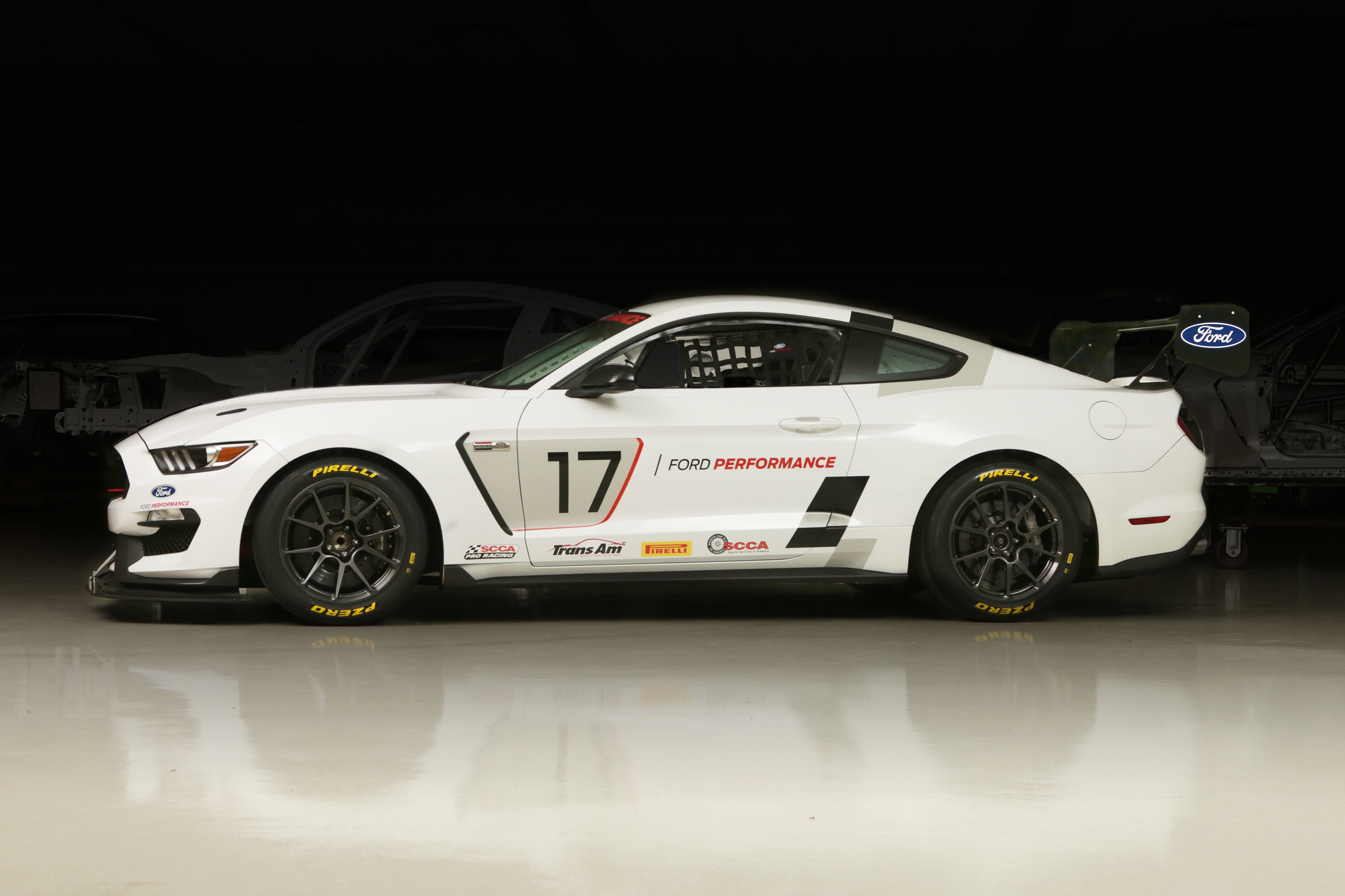 A white Mustang viewed from the side with the number 17 on it.