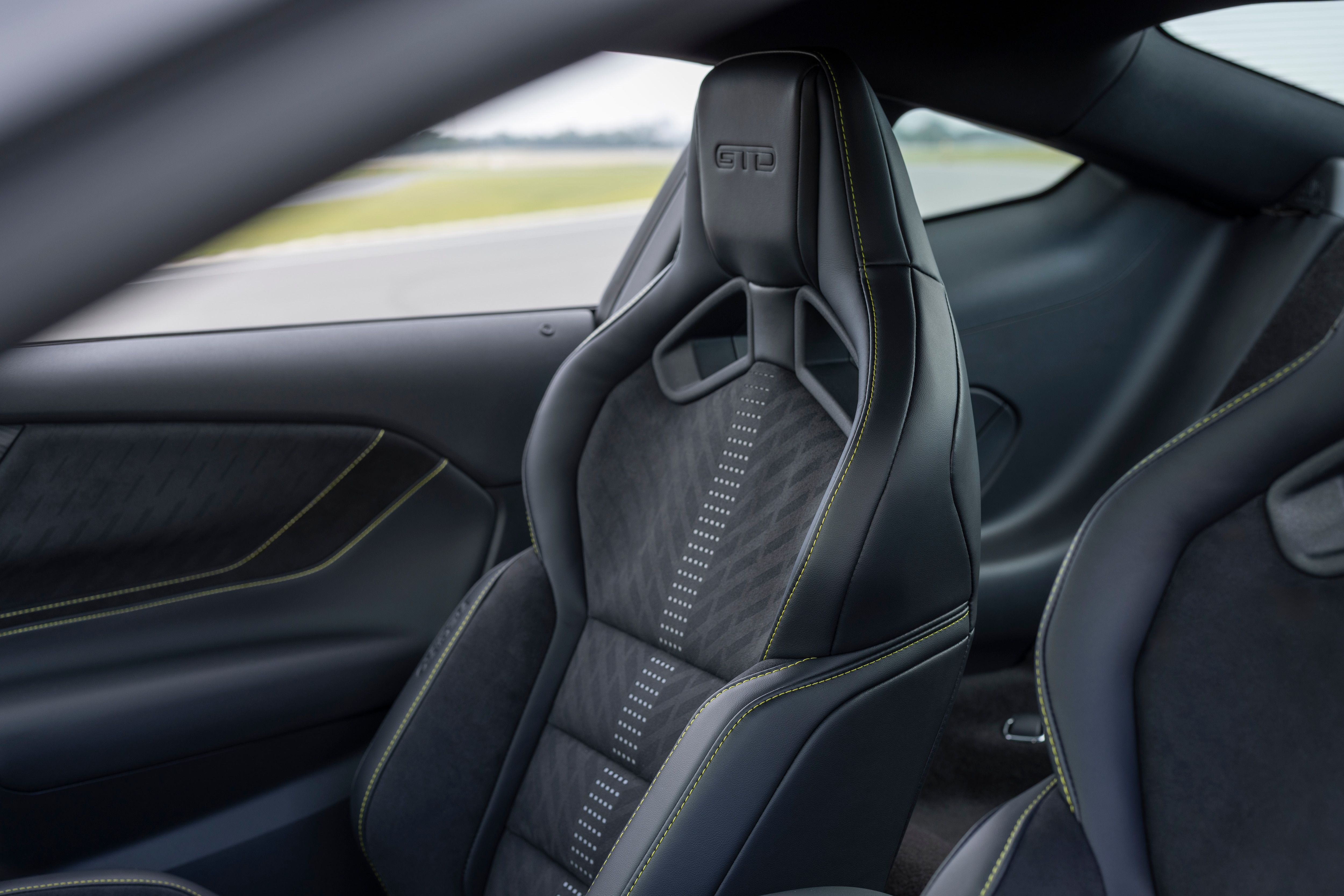 New Mustang Liquid Carbon interior shows lime green stitching on black and grey interior fabric.