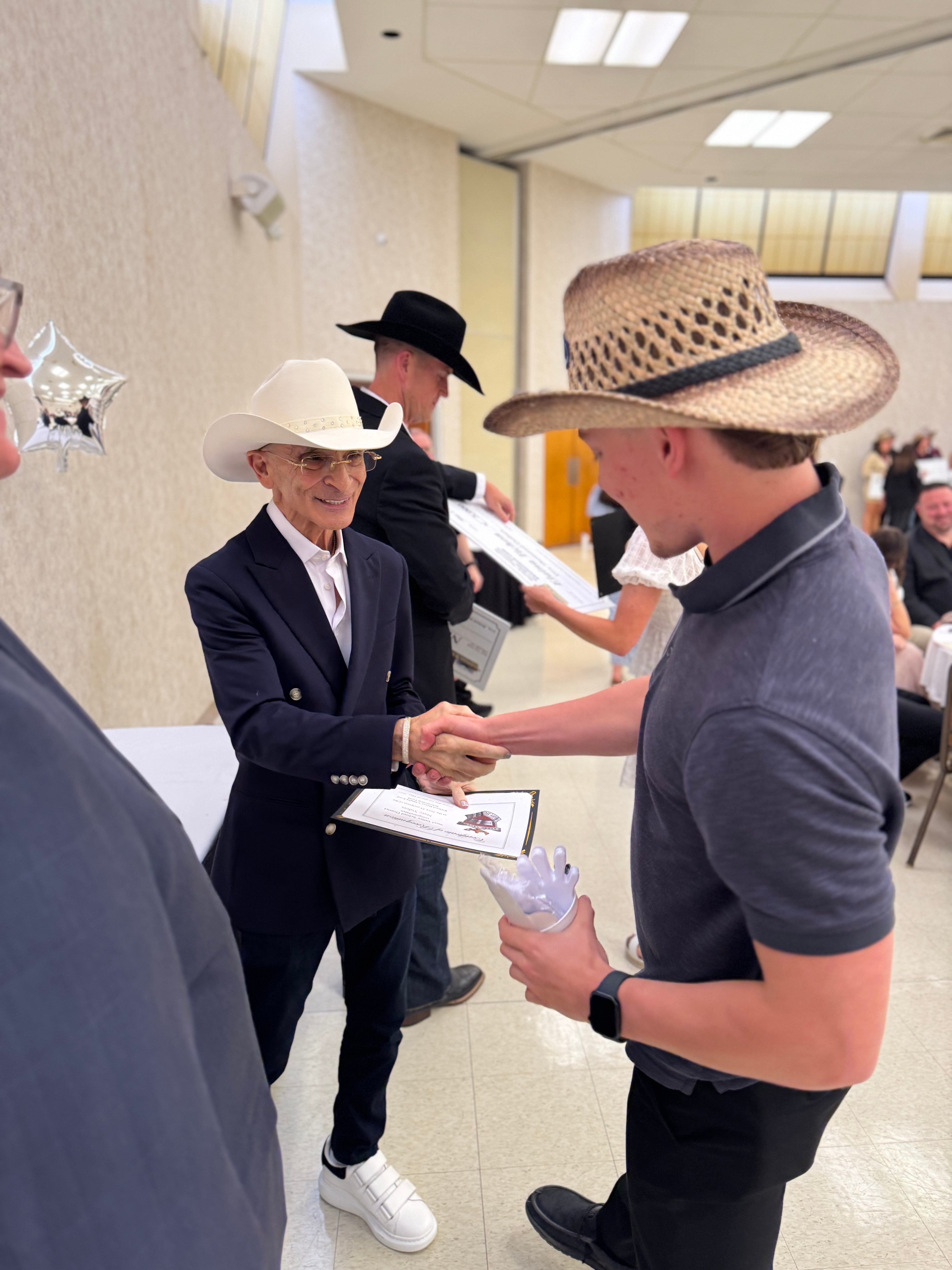 Richard Bazzy shakes hands with a scholarship winner.