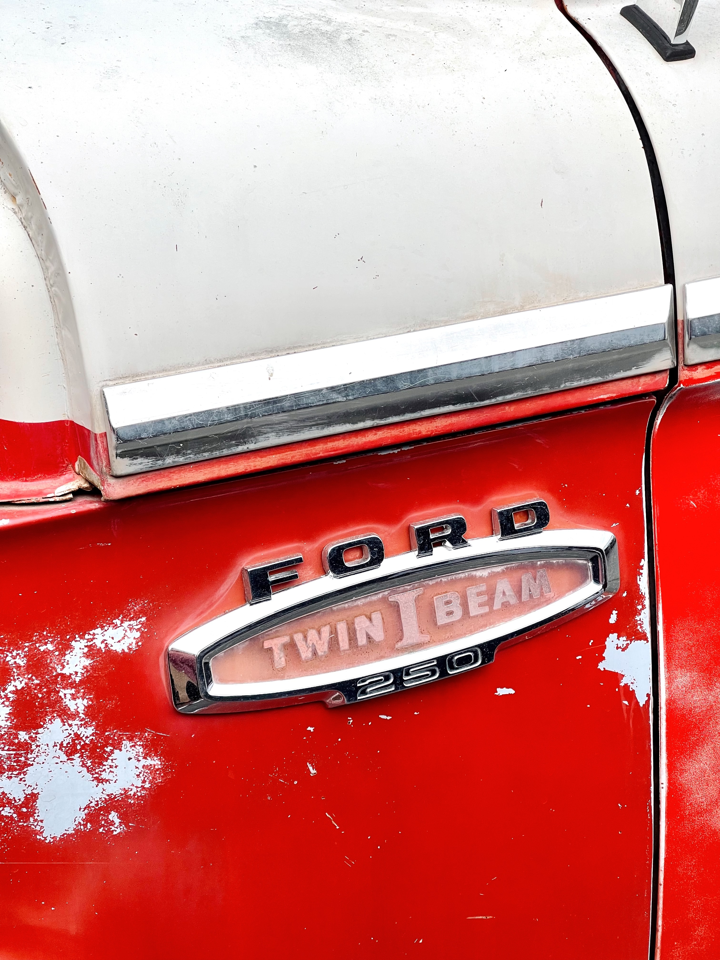 The words "Ford 250 Twin I Bear" on the side of a red 1966 Ford F-250.