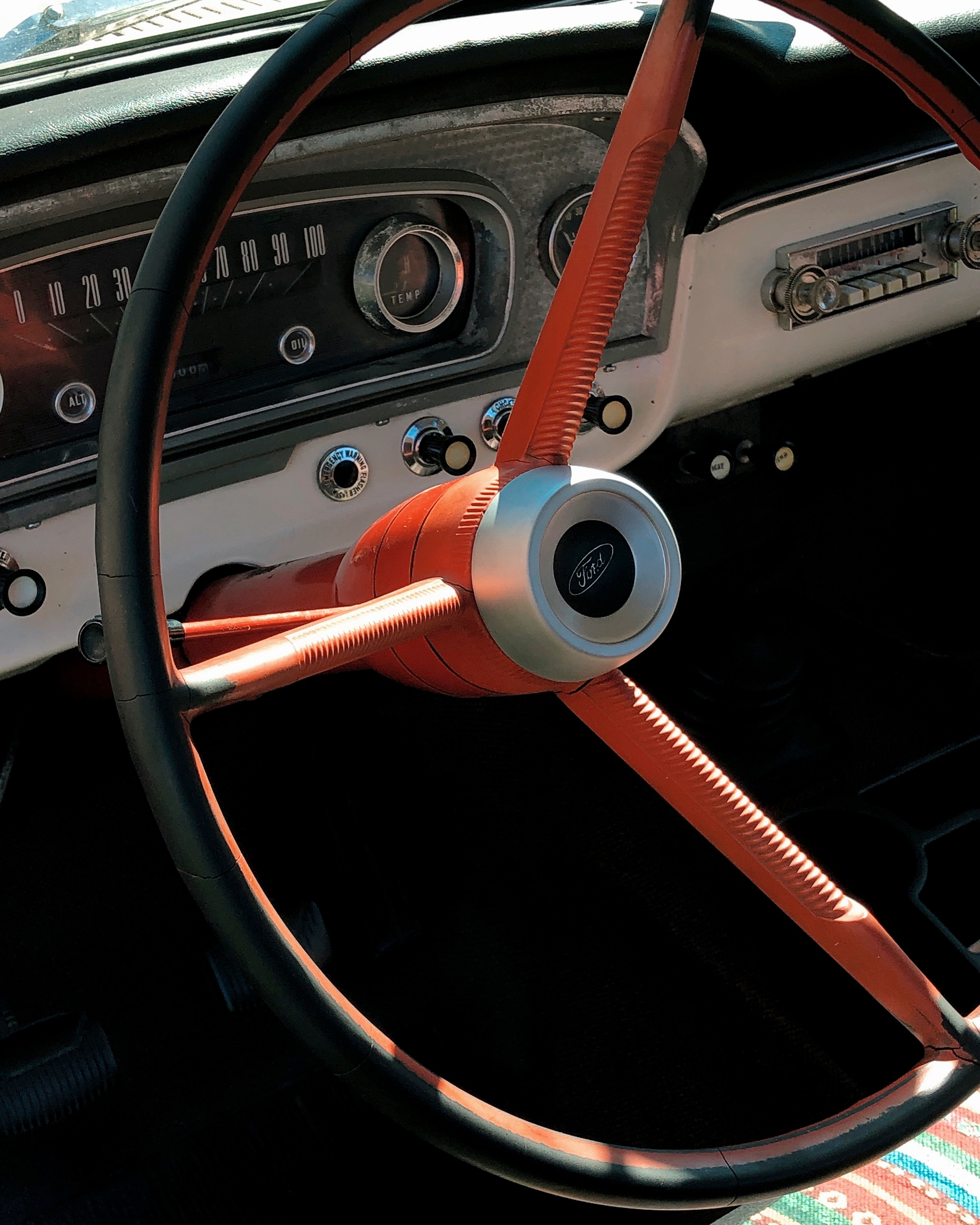 A red steering wheel column in a 1966 Ford F-250.