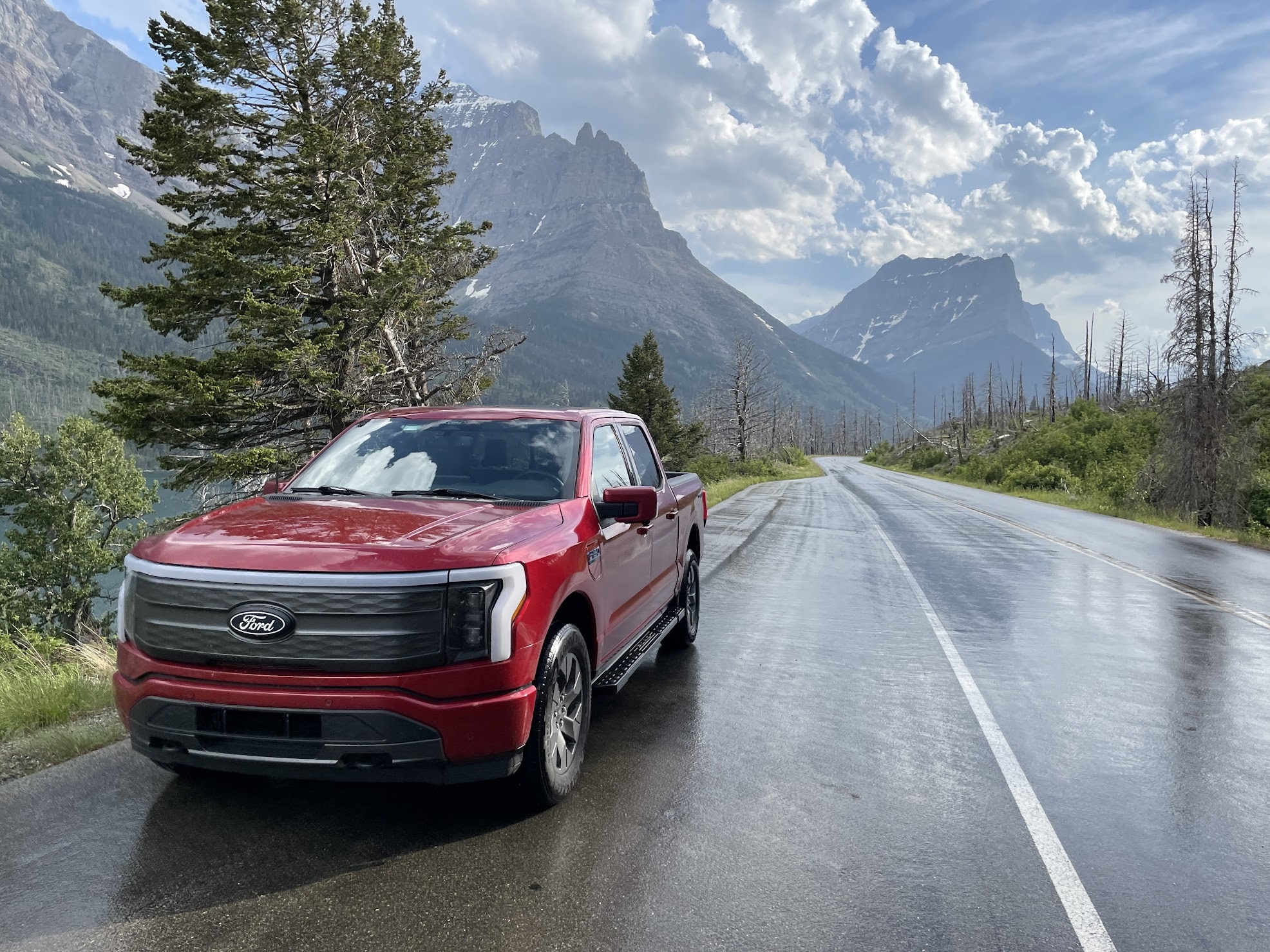 A red F-150 Lightning with a mountainous formation in the background.