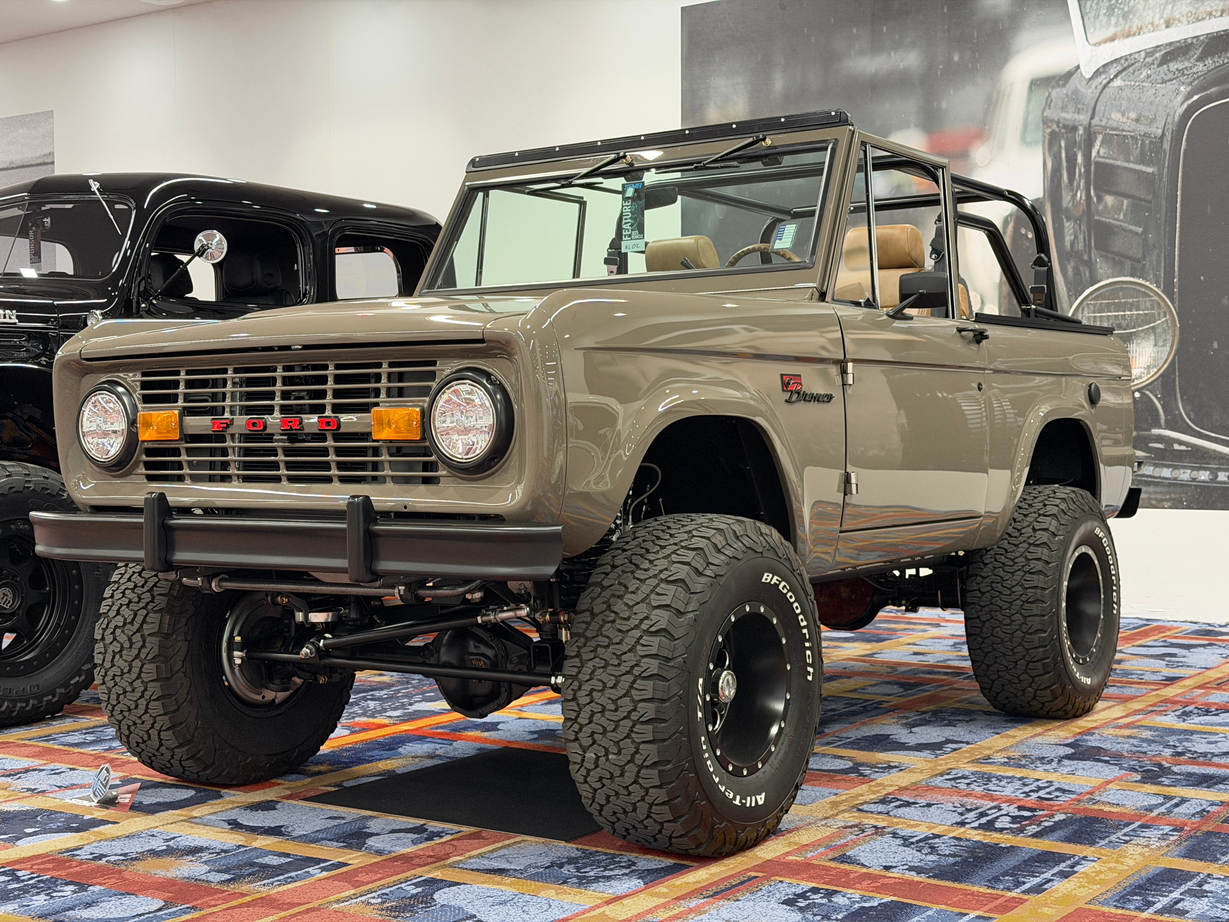 A vintage-looking brown Bronco displayed at a car show