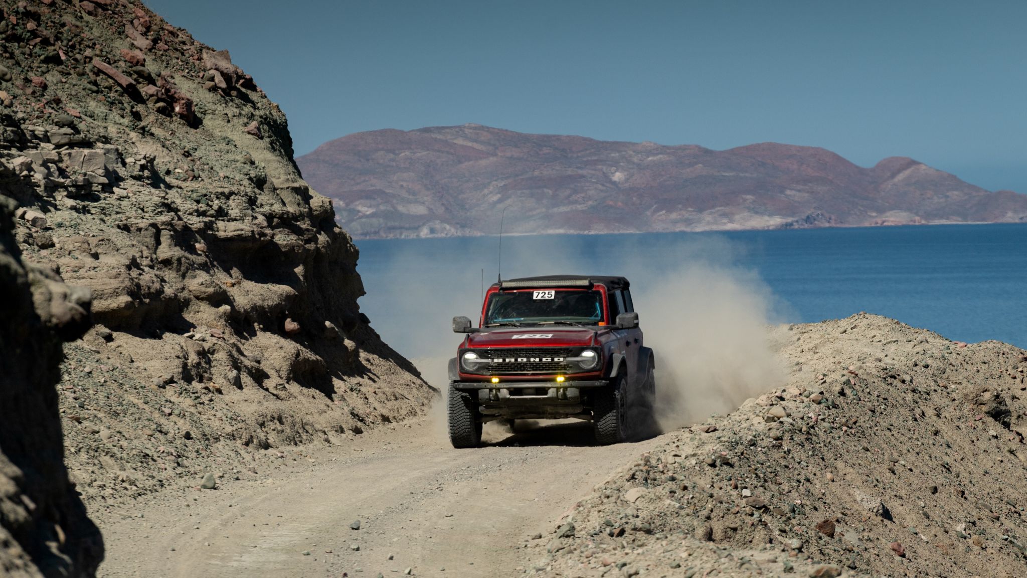 2024 Ford Bronco® Wildtrak® model with optional equipment, available Ford Accessories, aftermarket equipment, and extra-cost color option shown. Professional driver on closed course. Do not attempt. Always consult the Owner’s Manual before off-road driving, know your terrain and trail difficulty, and use appropriate safety gear.