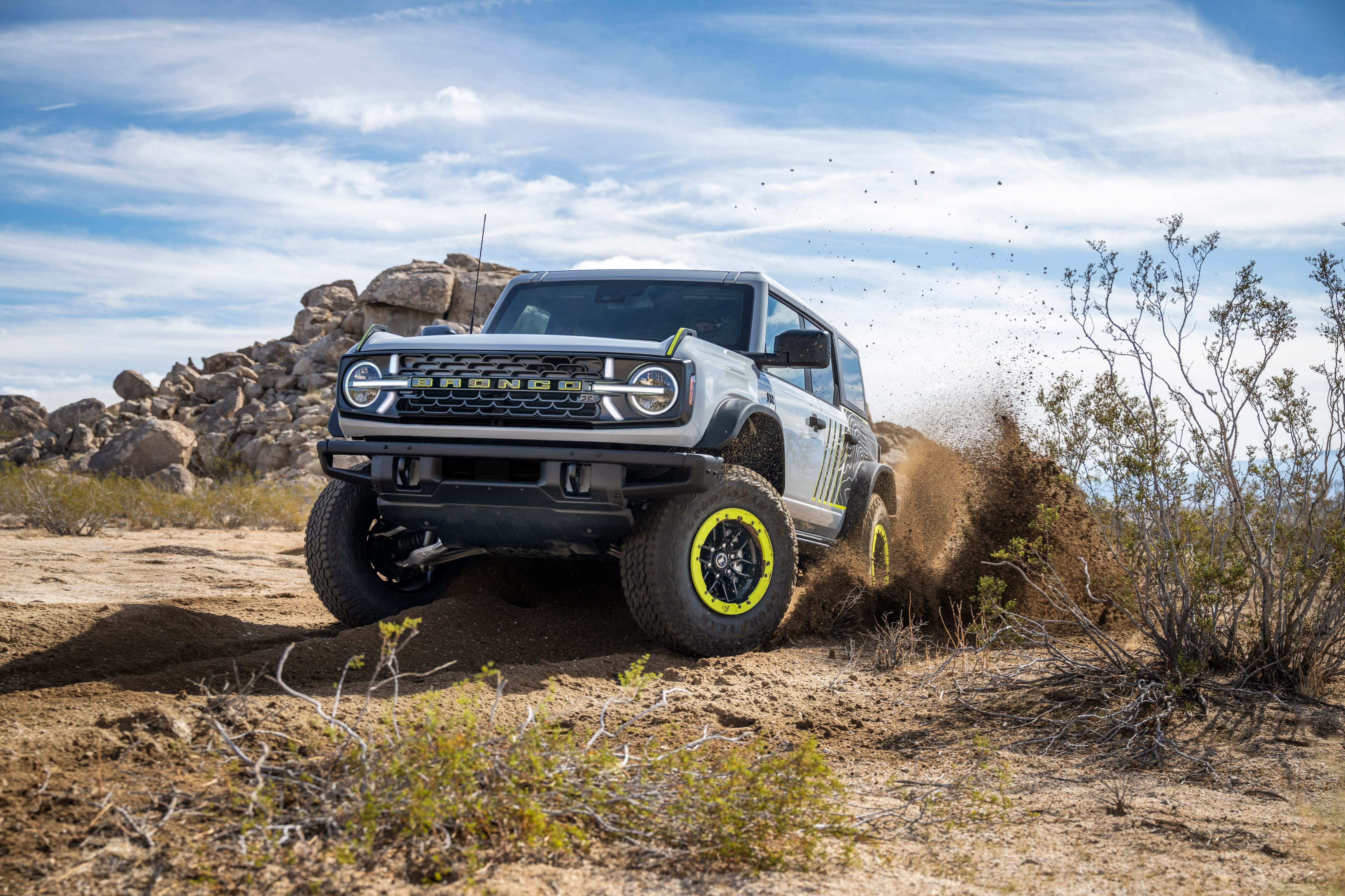 The front of the Bronco RTR, grey with lime green highlights, kicking up dirt