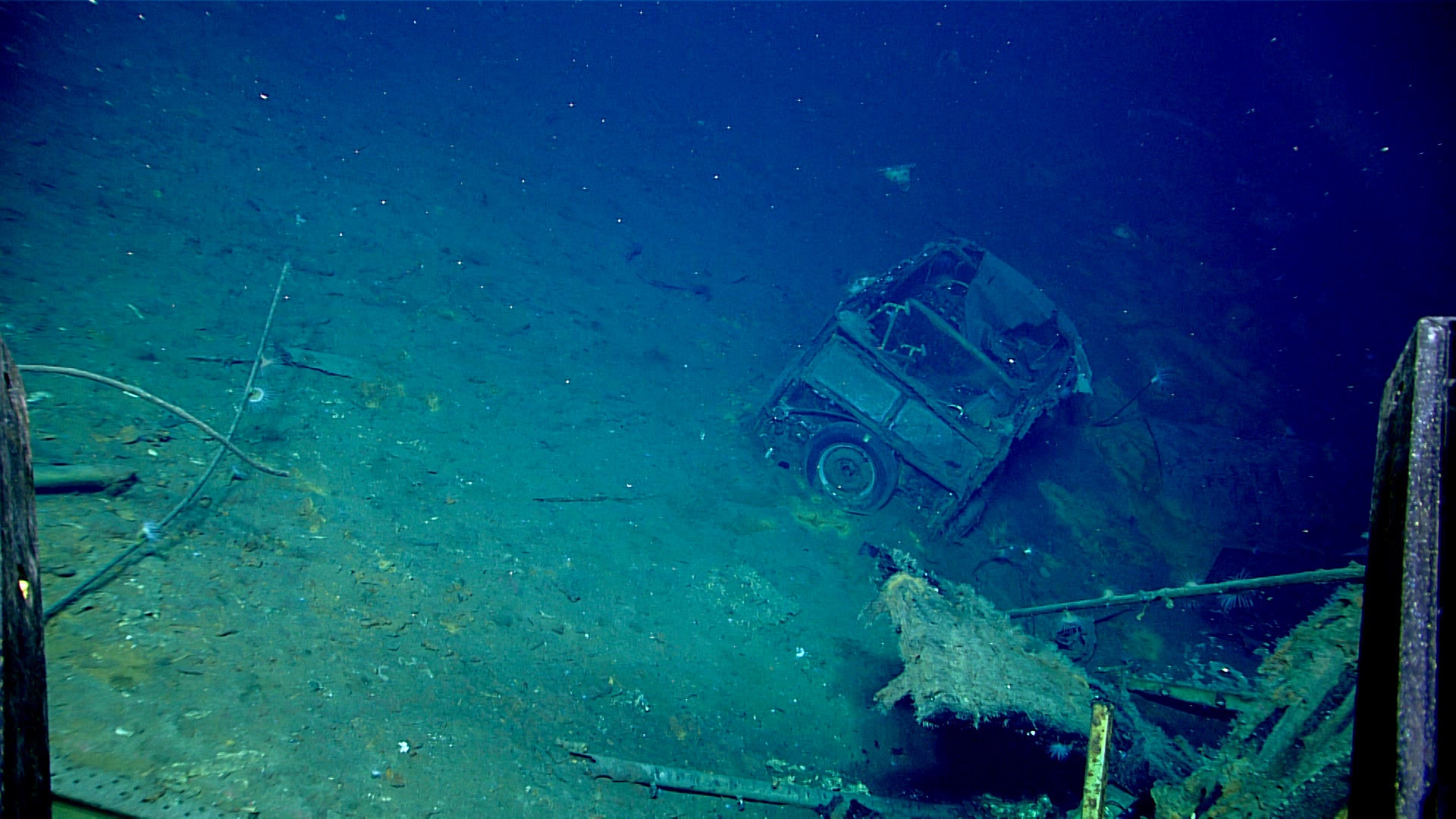 This image of an automobile on USS Yorktown first discovered during the April 19 dive and further explored on April 20 shows the car’s boxy shape, canvas top, chrome bumper, and spare tire on the back. Image courtesy of NOAA Ocean Exploration, 2025 Beyond the Blue.