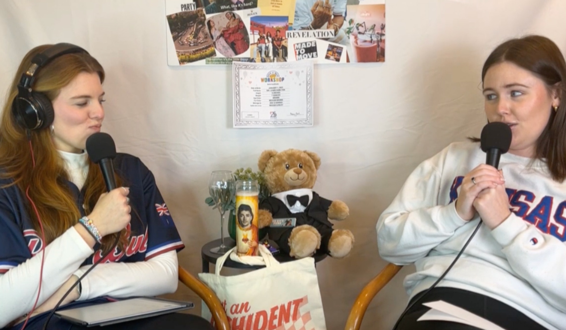 Two women seated next to each other talk into microphones.