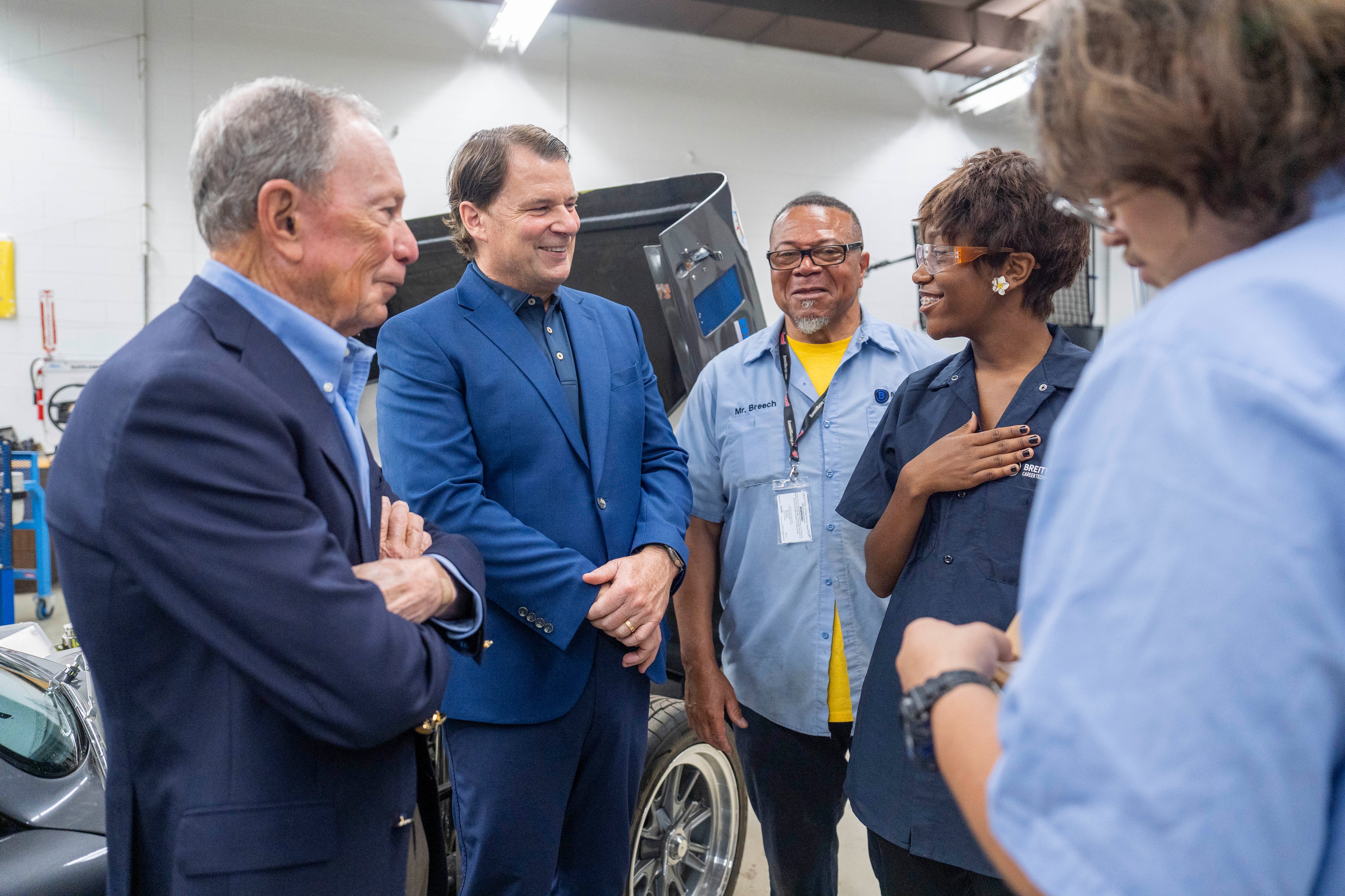 Jim Farley, CEO of Ford, and Former Mayor Mike Bloomberg of New York City meet Dallis and Jesus and ask them about their experiences in the auto technician class, on June 8, 2026, at the Breithaupt Career and Technical Center, in Detroit, Michigan.