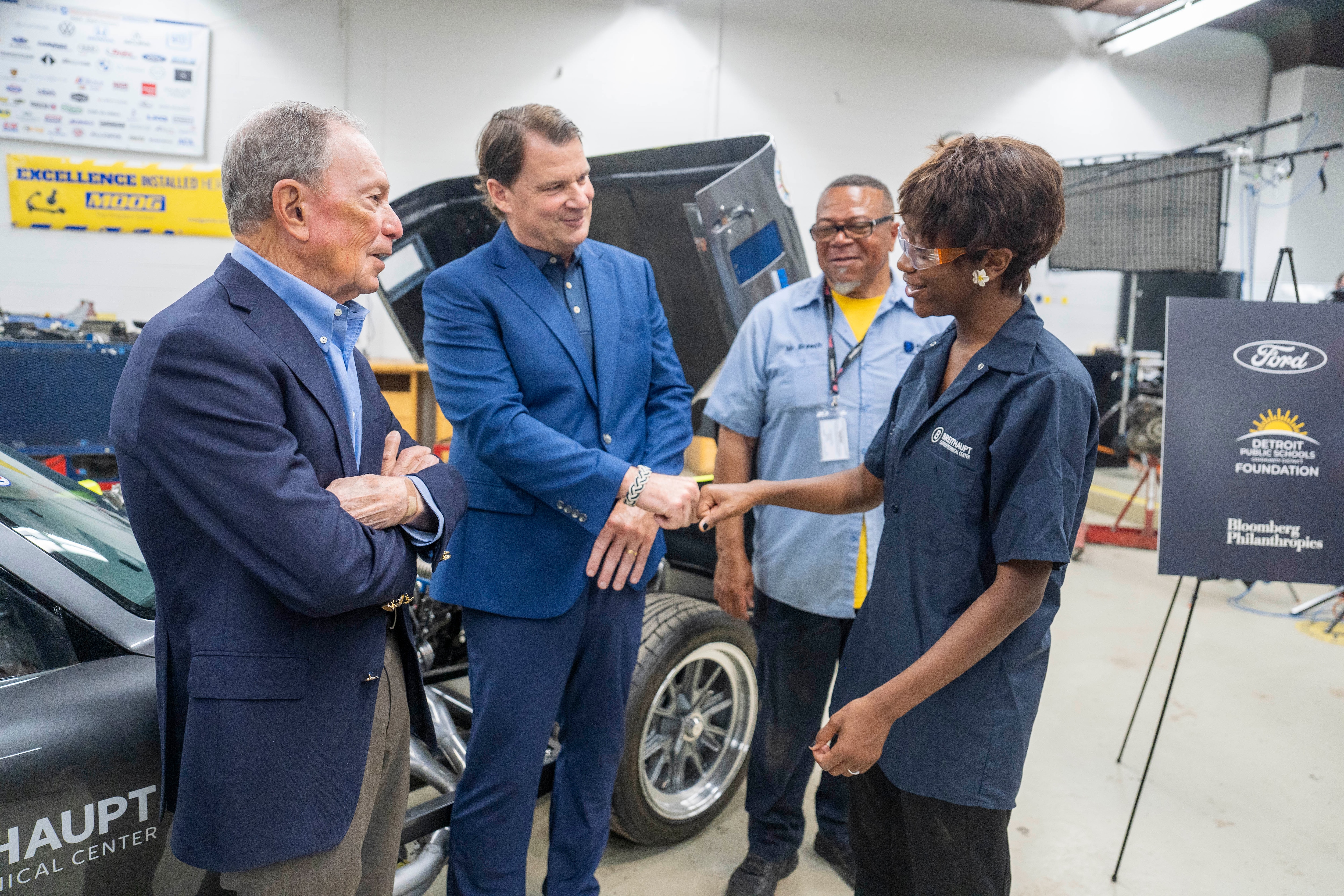 Jim Farley, CEO of Ford, and Former Mayor Mike Bloomberg of New York City meet Dallis and Jesus and ask them about their experiences in the auto technician class, on June 8, 2026, at the Breithaupt Career and Technical Center, in Detroit, Michigan.