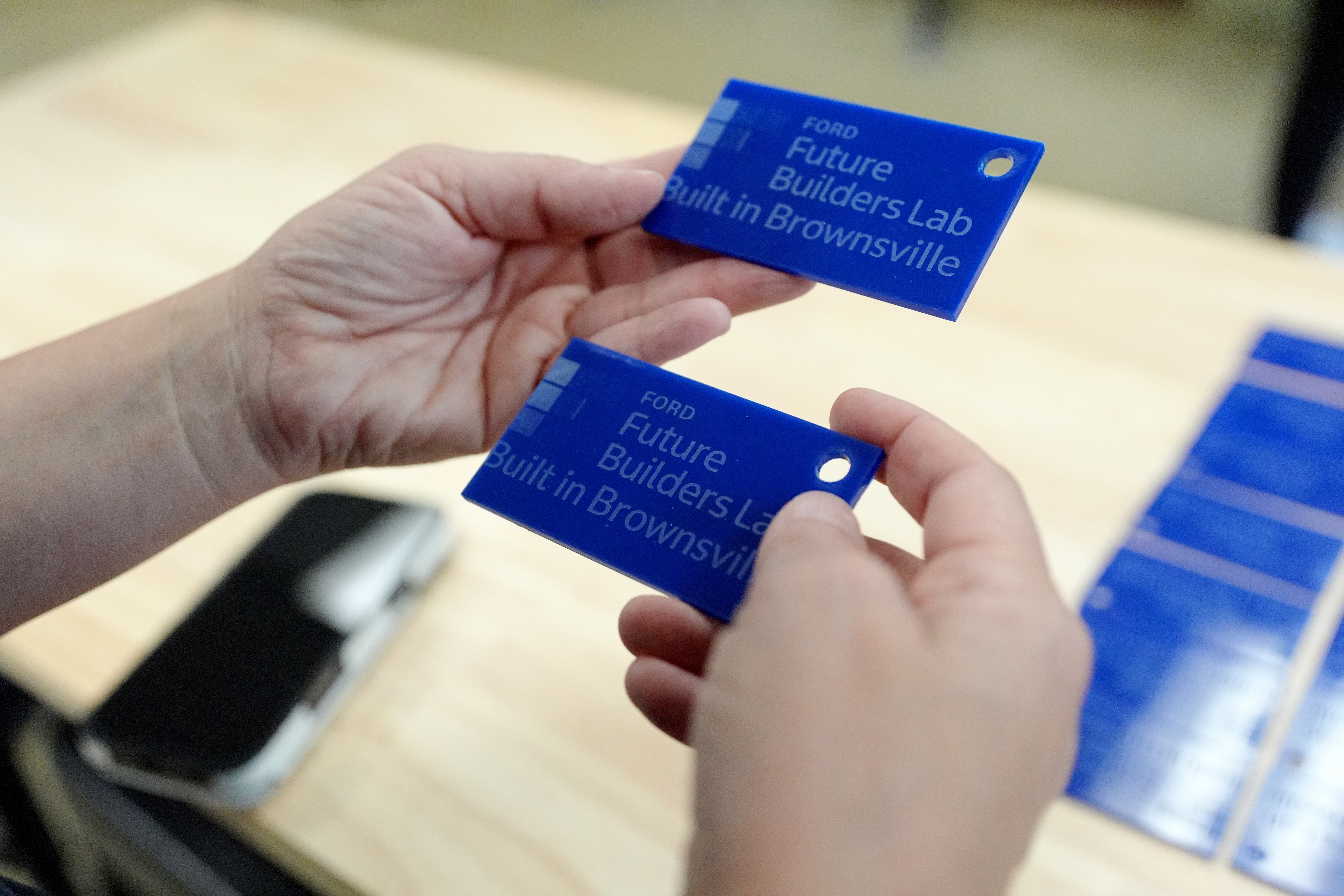 A teacher at the Haywood High School’s Career and Technical Education (CTE) center, holds luggage tags made by students in the Brownsville, Tenn., school using technical equipment in the school’s Ford Future Builders Lab, April 14, 2026. The lab is one of several that opened this academic year in West Tennessee to assist K-12 students and their teachers to learn about tools of skilled trades, including laser cutting, 3D printing and coding. (Rogelio V. Solis for Ford Communications)