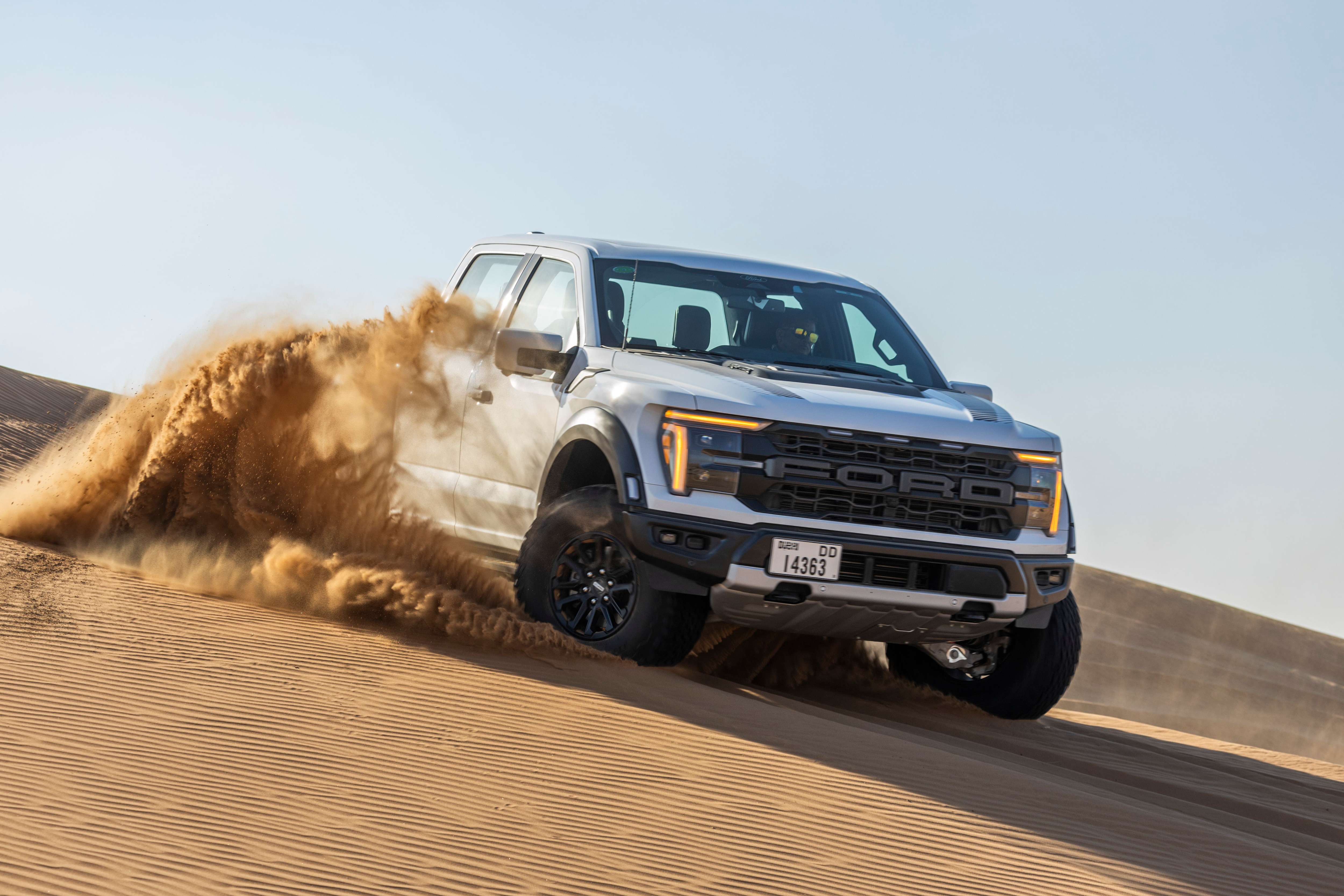 An F-150 Raptor drives through the desert