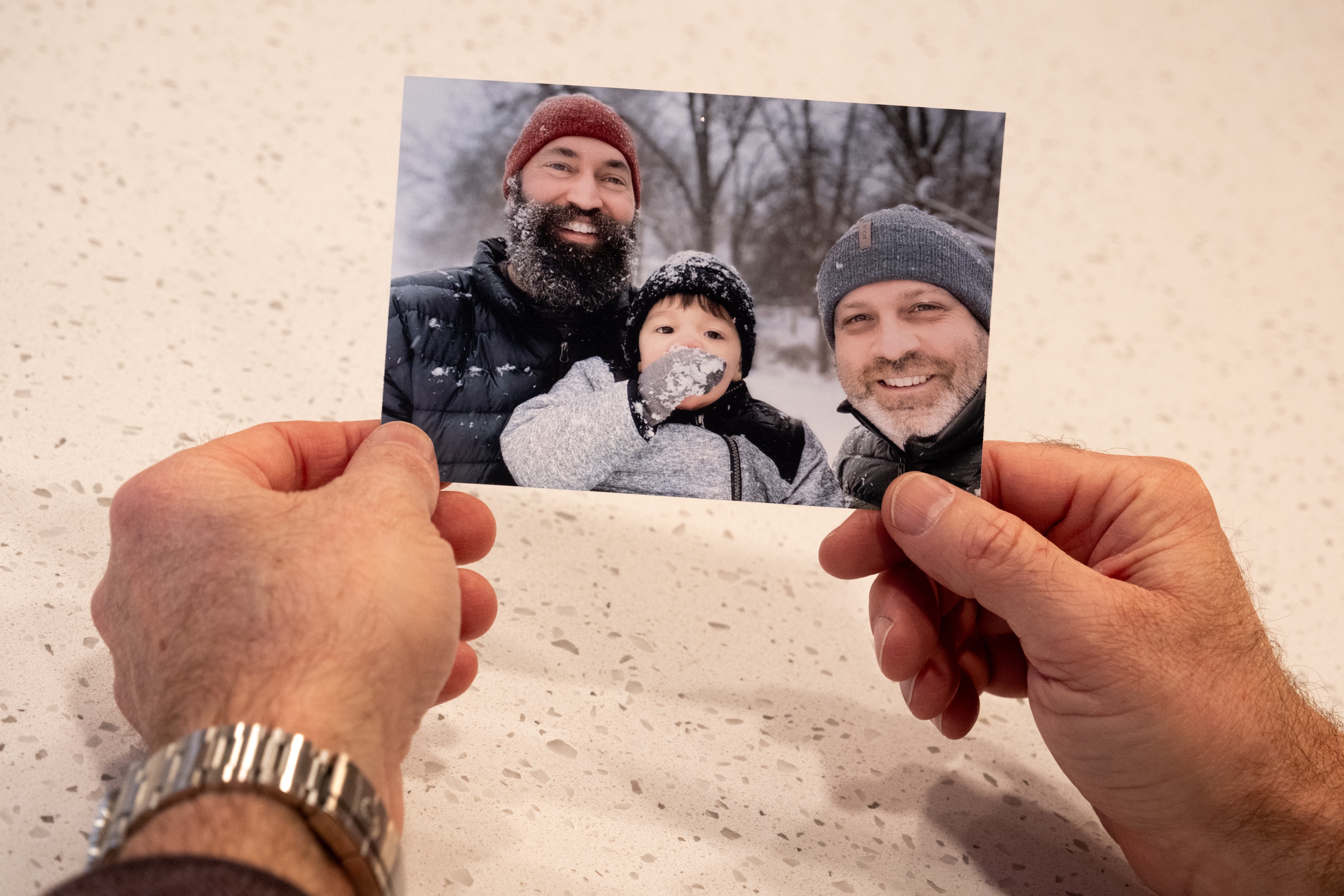 Todd holding a picture of himself, Clayton, and Oliver.