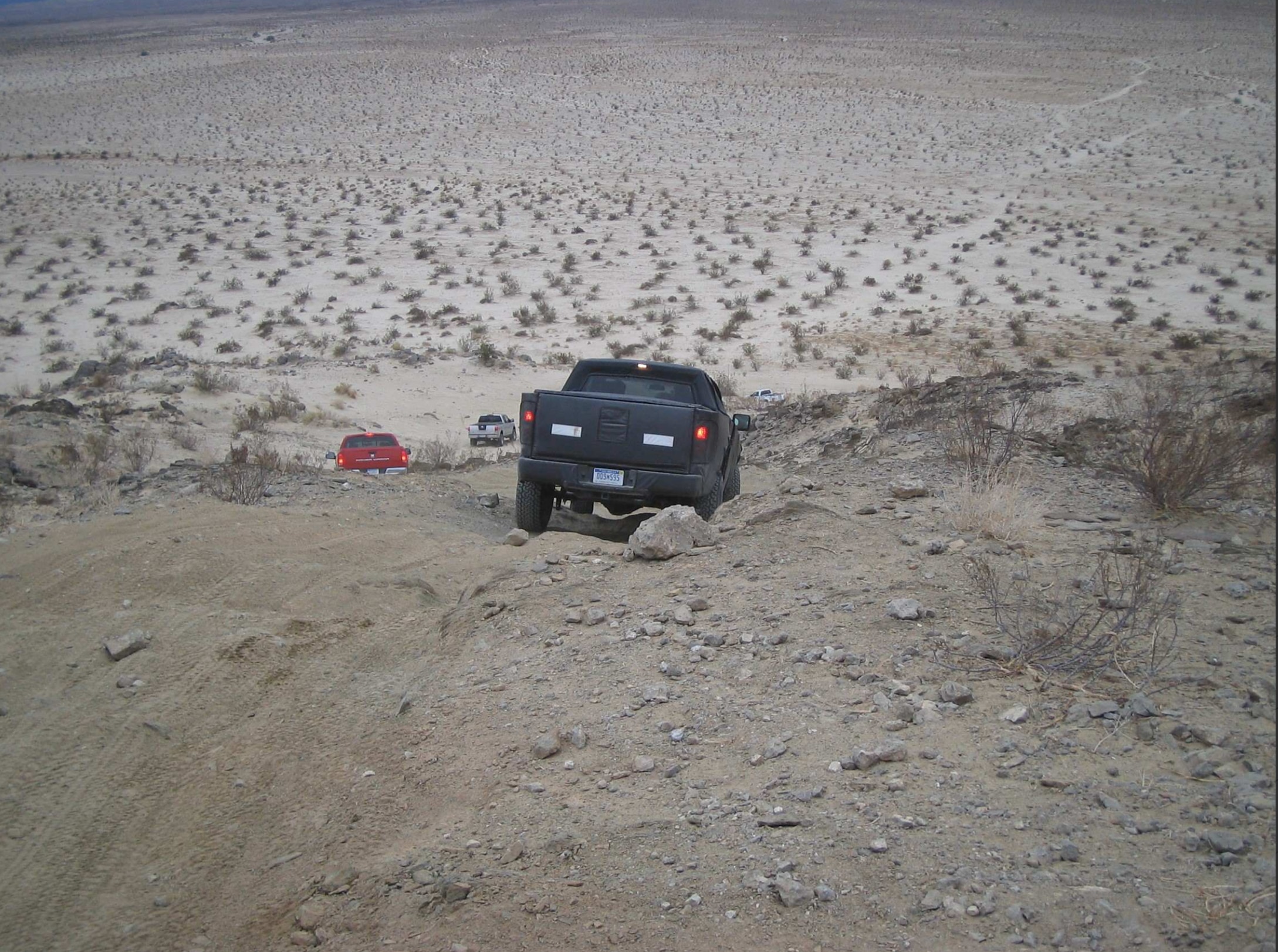 A convoy of prototype Raptors traverses rugged terrain during multi-vehicle trail testing.