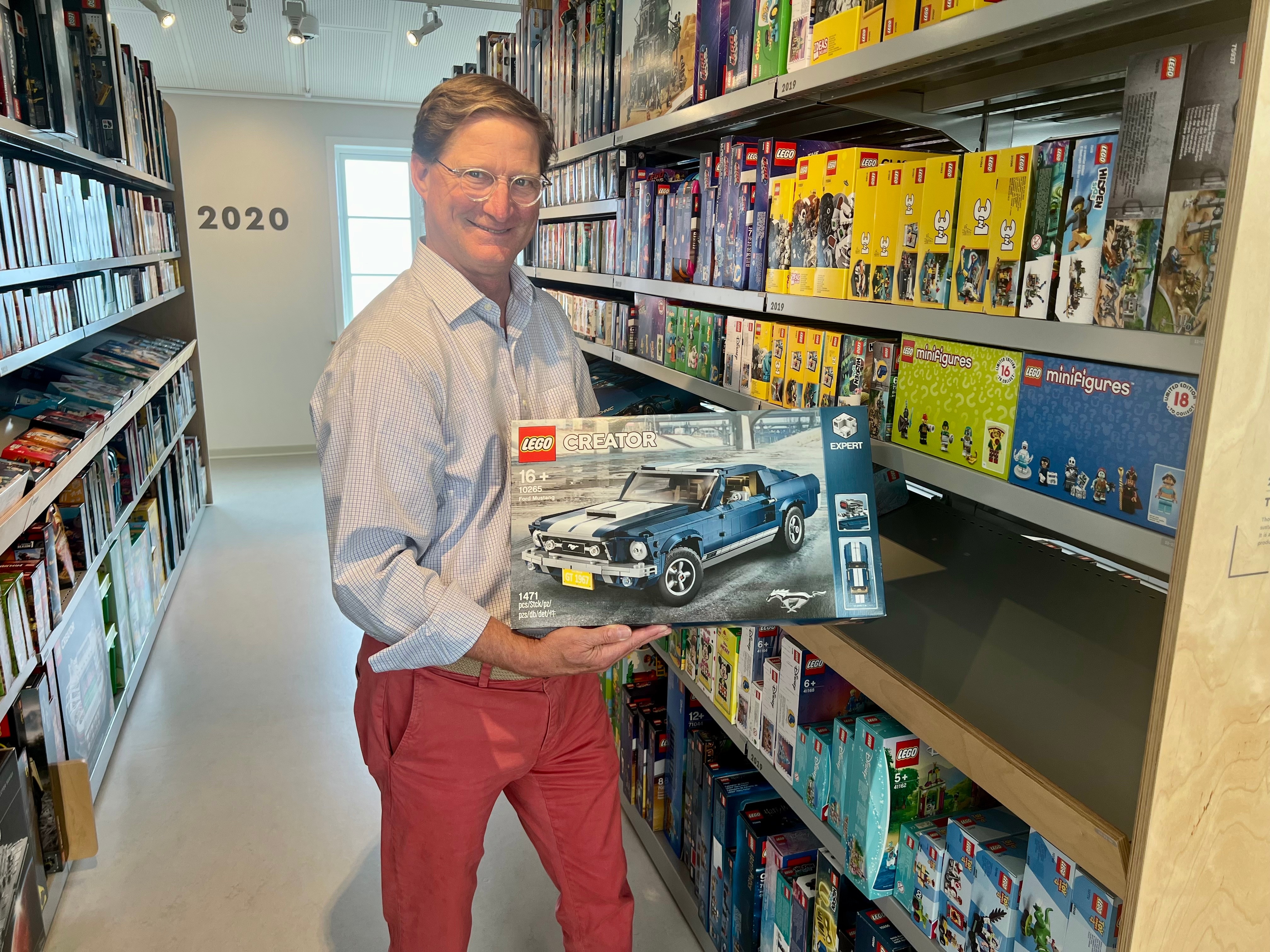 Ted Ryan holds a LEGO 67 Mustang GT Fastback model in the Lego Vault.