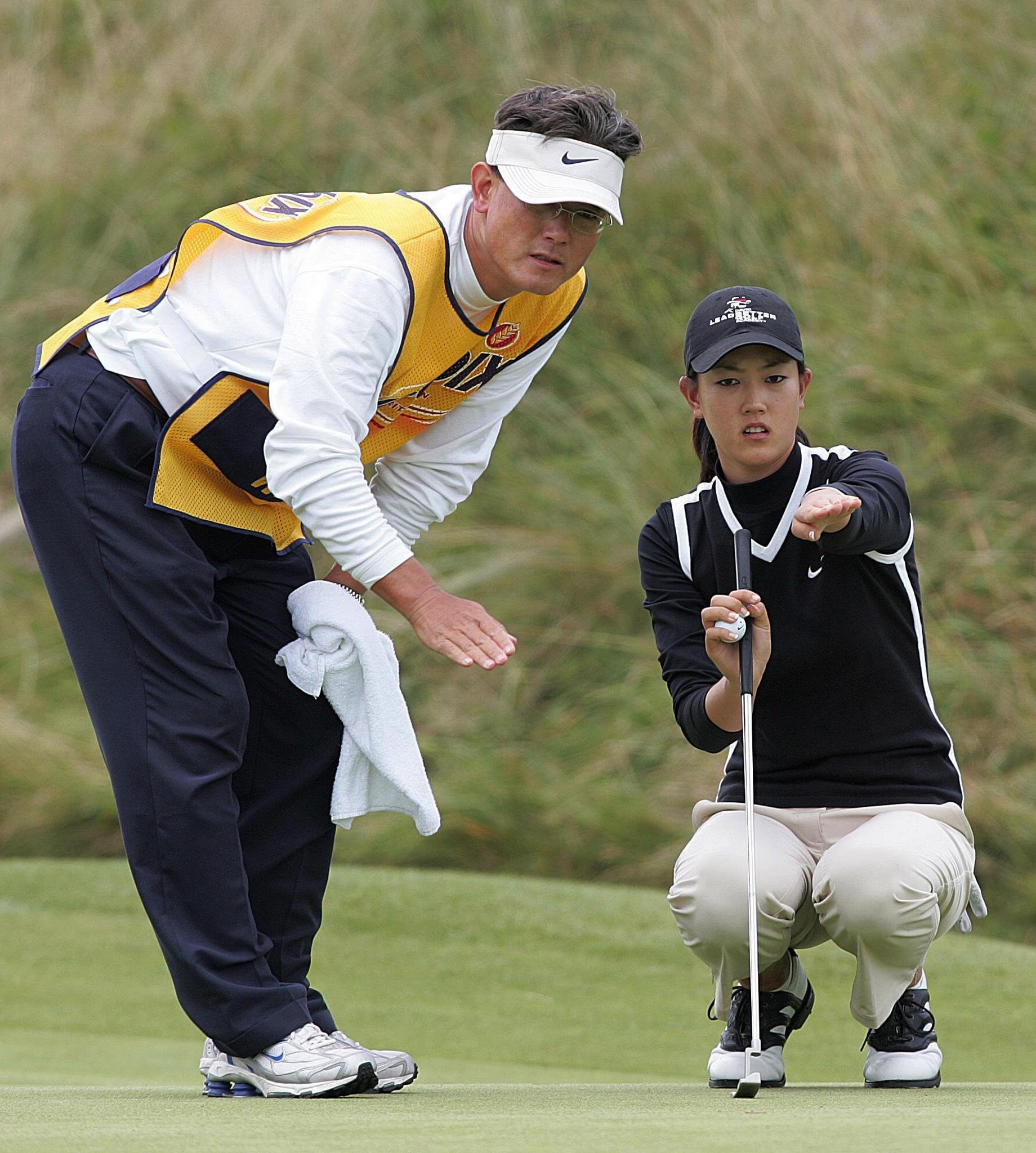 USA's Michelle Wie lines up a putt on the 6th hole with her father and caddie BJ.   (Photo by Martin Rickett - PA Images/PA Images via Getty Images)