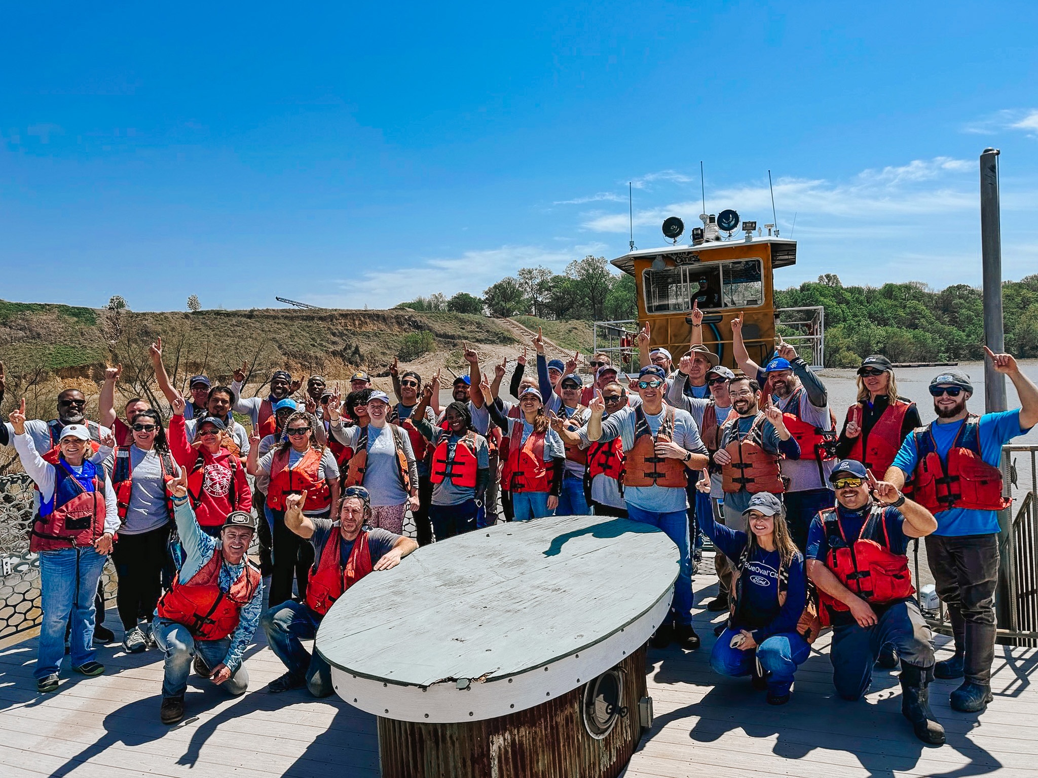 Ford volunteers celebrate with Living Lands & Waters team after a day of cleaning up on the water.